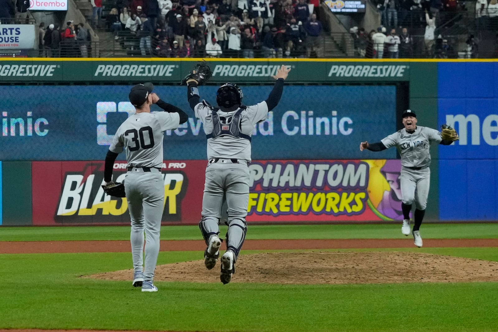 New York Yankees' Luke Weaver (30), Jose Trevino (39) and Anthony Volpe celebrate after Game 5 of the baseball AL Championship Series against the Cleveland Guardians Saturday, Oct. 19, 2024, in Cleveland. The Yankees won 5-2 to advance to the World Series. (AP Photo/Godofredo A. Vásquez )