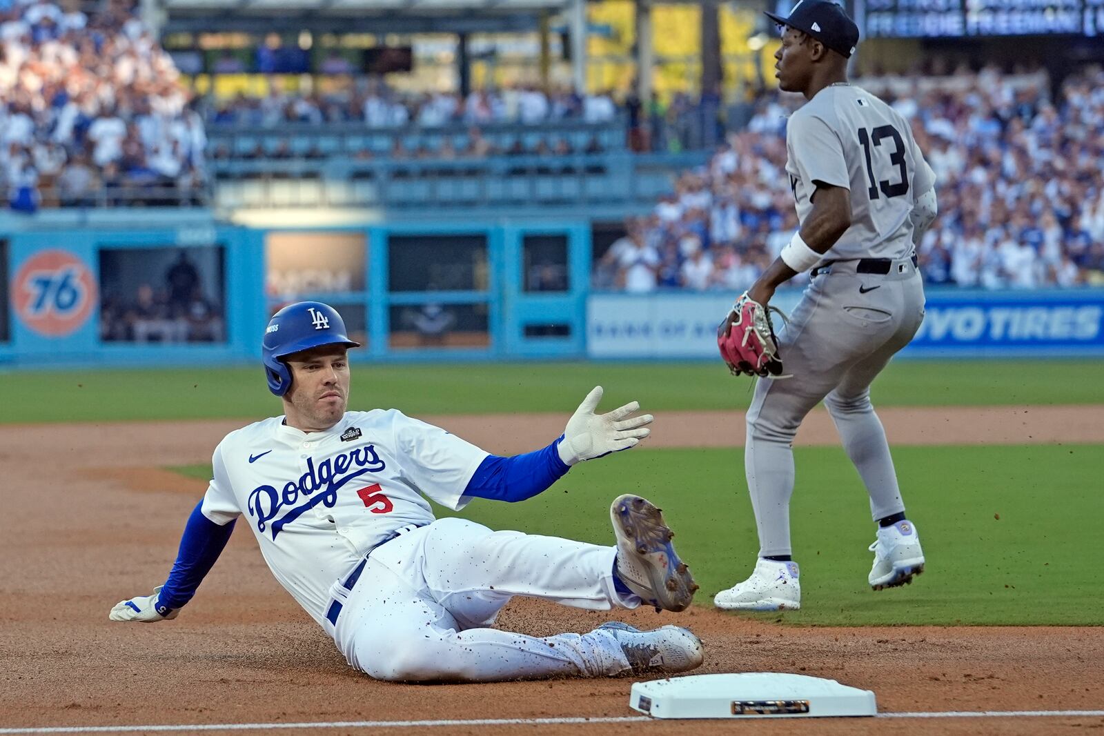 Los Angeles Dodgers' Freddie Freeman (5) slides into third base after hitting a triple against the New York Yankees during the first inning in Game 1 of the baseball World Series, Friday, Oct. 25, 2024, in Los Angeles. (AP Photo/Godofredo A. Vásquez)