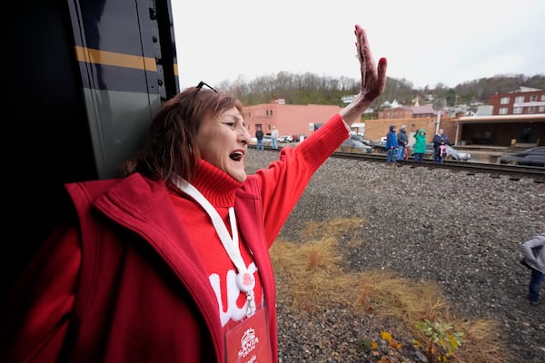 Angie Hensley waves to people during the 82nd run of the CSX Santa Train, Saturday, Nov. 23, 2024, in St. Paul, Va. (AP Photo/George Walker IV)