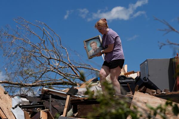 Hailee Allen holds a family picture saved from Lynn and Don White's home, Saturday, May 17, 2025, in London, Ky (AP Photo/Carolyn Kaster)