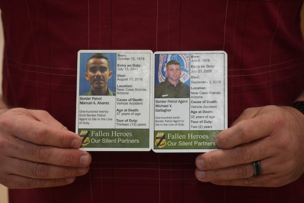 Border Patrol chaplain and instructor Jason Wilhite holds two Silent Partner cards he carries with him at all times showing two of his colleagues that died in the line of duty, Wednesday, Nov. 20, 2024, in Dania Beach, Fla. (AP Photo/Marta Lavandier)