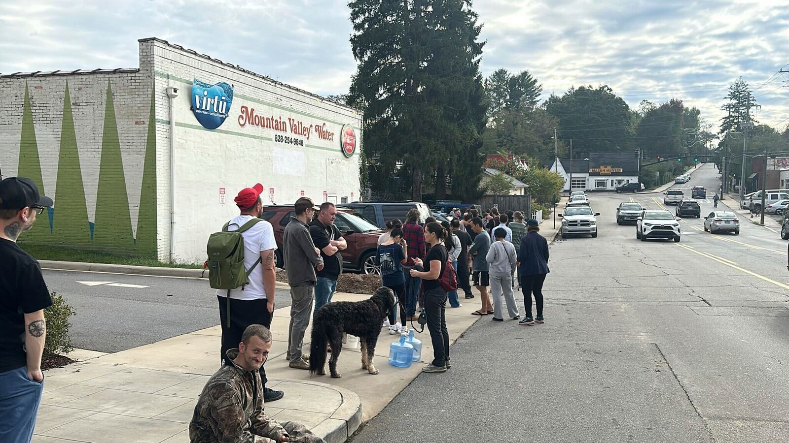 People wait to gather water at Mountain Valley Water in the aftermath of Hurricane Helene in West Asheville, N.C., Monday, Sept. 30, 2024. (AP Photo/Jeffrey Collins)