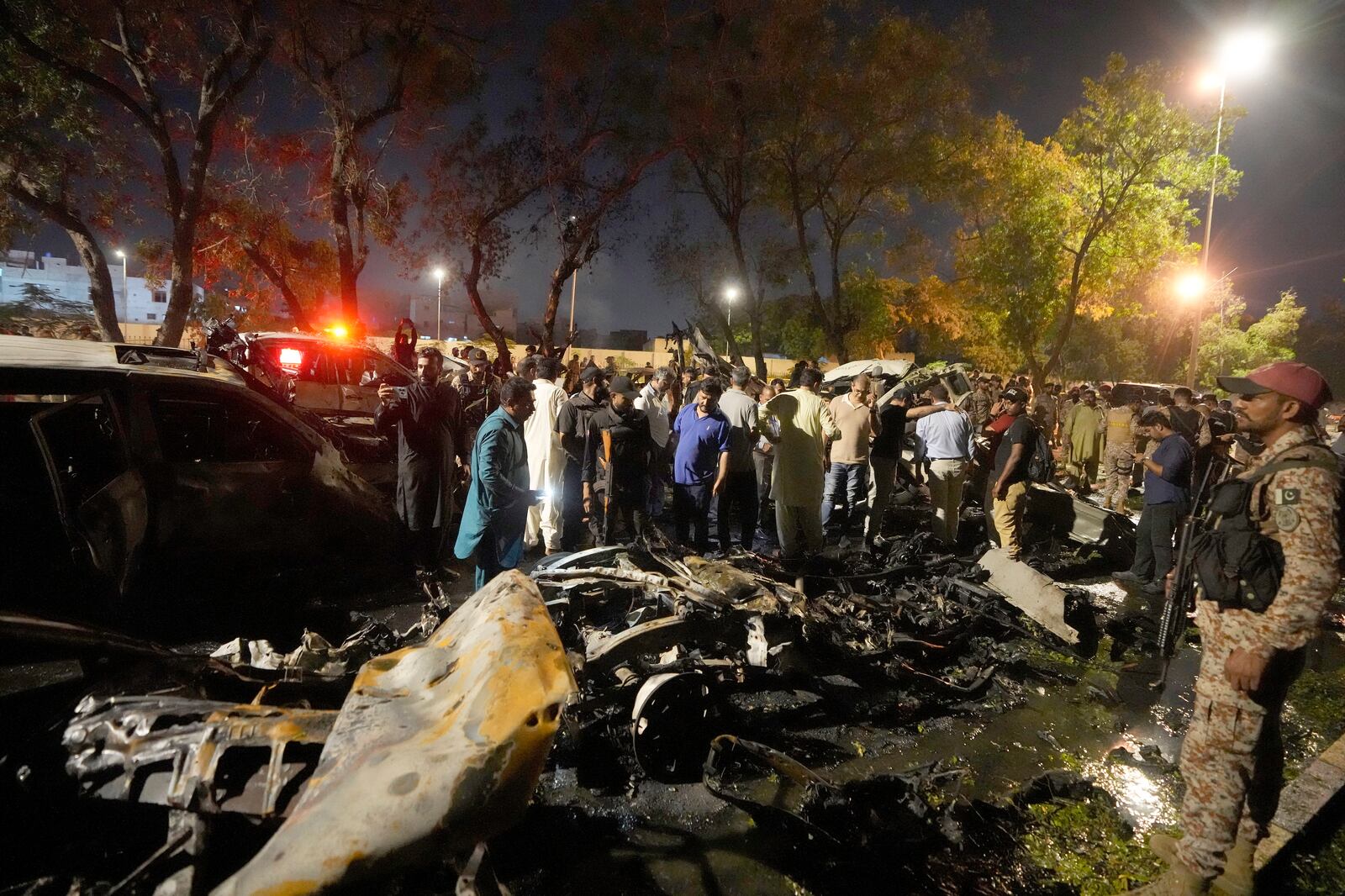 Security officials examine the site of an explosion that caused injures and destroyed vehicles outside the Karachi airport, Pakistan, Monday, Oct. 7, 2024. (AP Photo/Fareed Khan)