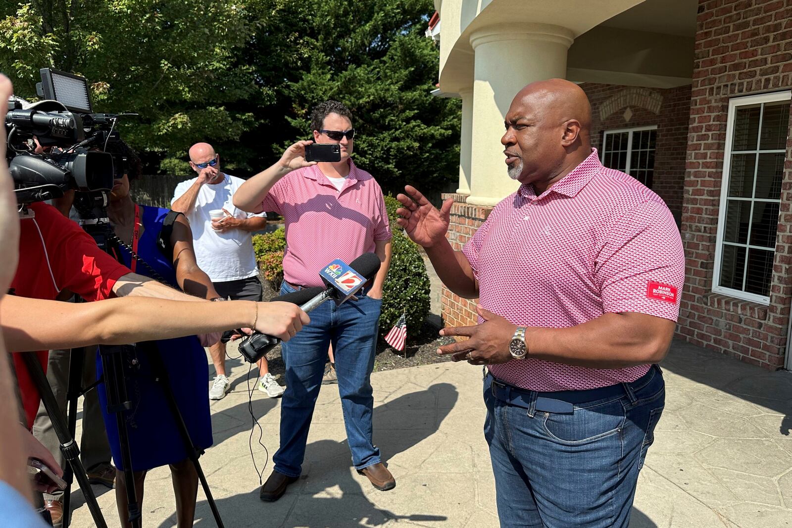 North Carolina Republican gubernatorial candidate Mark Robinson, right, speaks with reporters outside the Olympic Family Restaurant in Colfax, N.C., where Robinson held a campaign event on Monday, Aug. 26, 2024. (AP Photo/Gary D. Robertson)