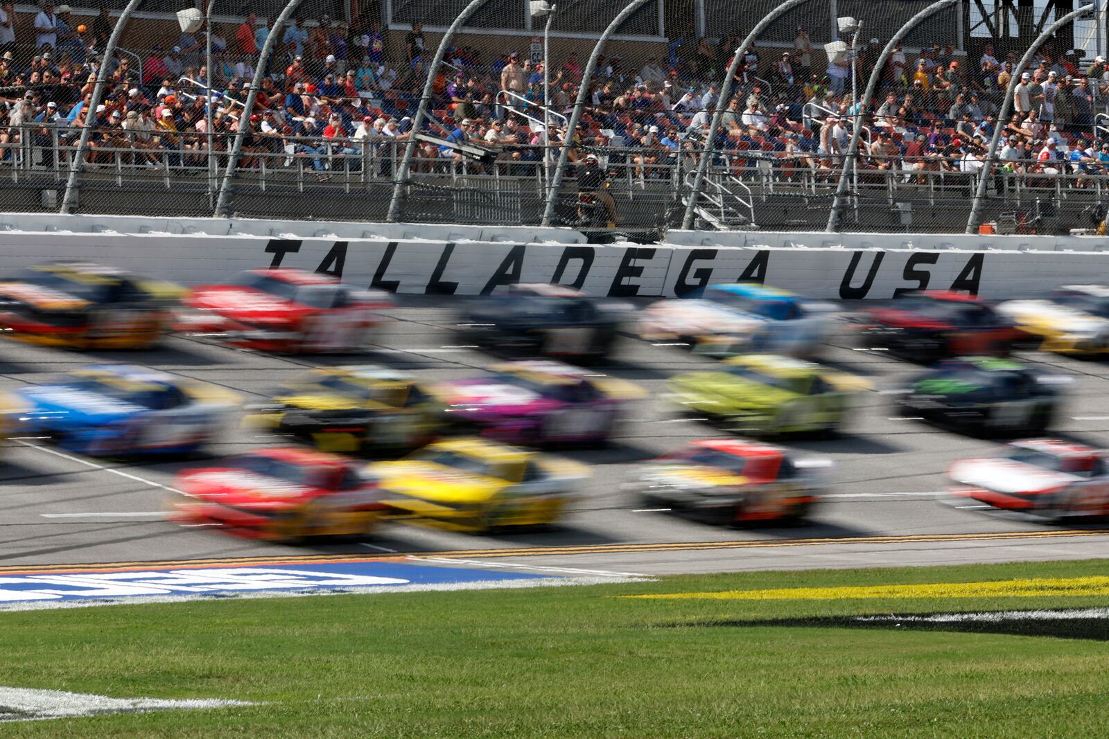 Drivers race down the front stretch three wide during a NASCAR Cup Series auto race at Talladega Superspeedway, Sunday, Oct. 6, 2024, in Talladega, Ala. (AP Photo/ Butch Dill)