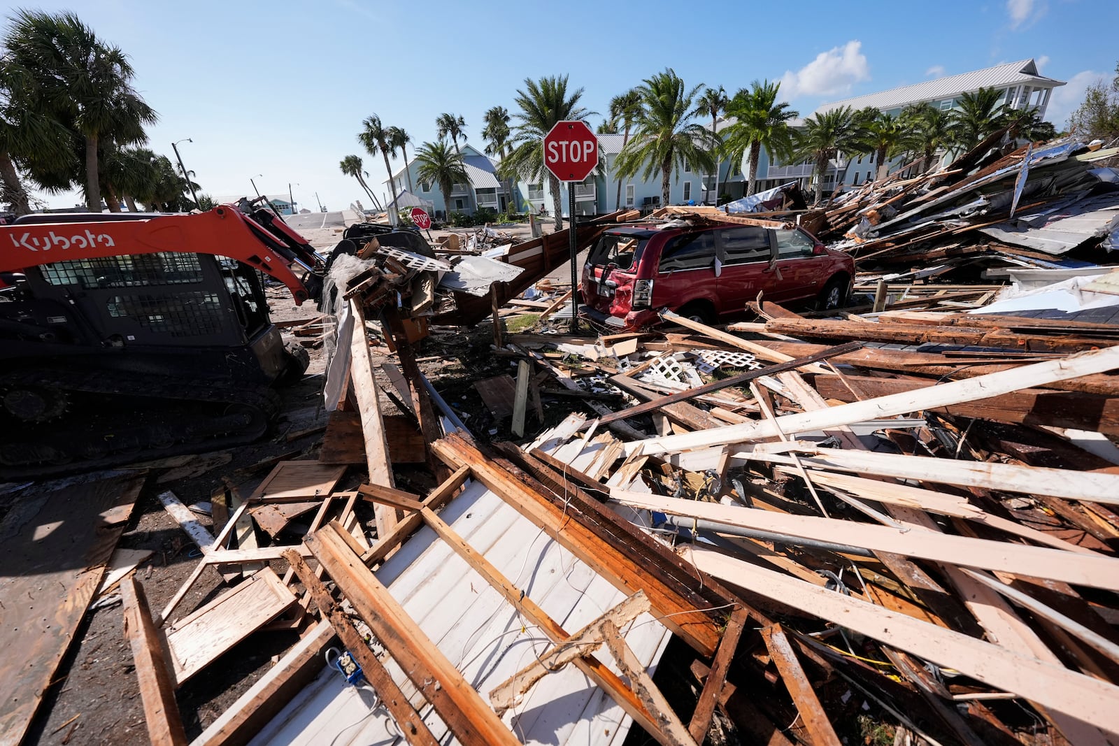 Workers clear debris in the aftermath of Hurricane Helene, in Cedar Key, Fla., Friday, Sept. 27, 2024. (AP Photo/Gerald Herbert)