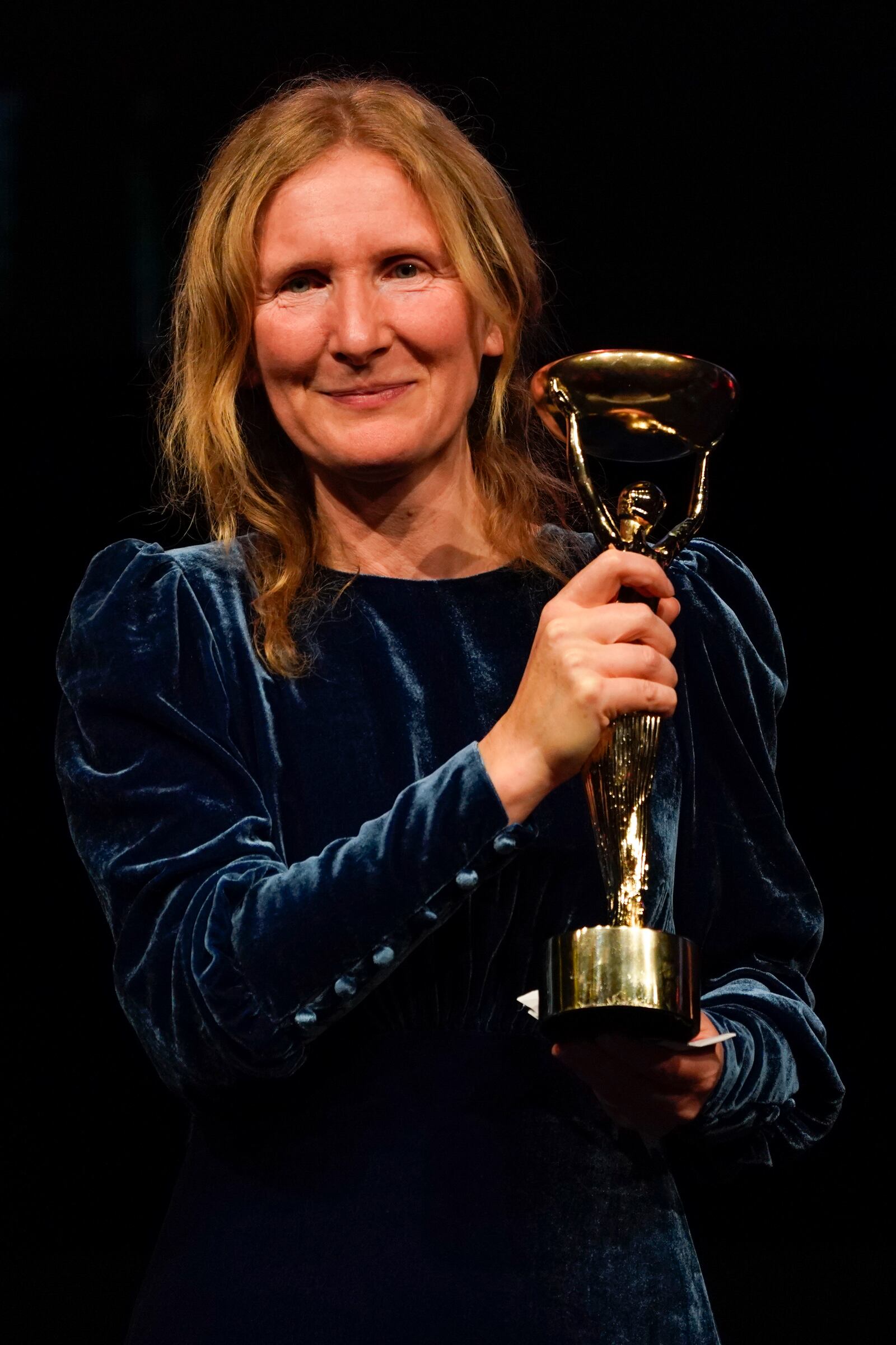 Samantha Harvey poses with the trophy after winning the Booker Prize award 2024, in London, Tuesday, Nov. 12, 2024. (AP Photo/Alberto Pezzali)