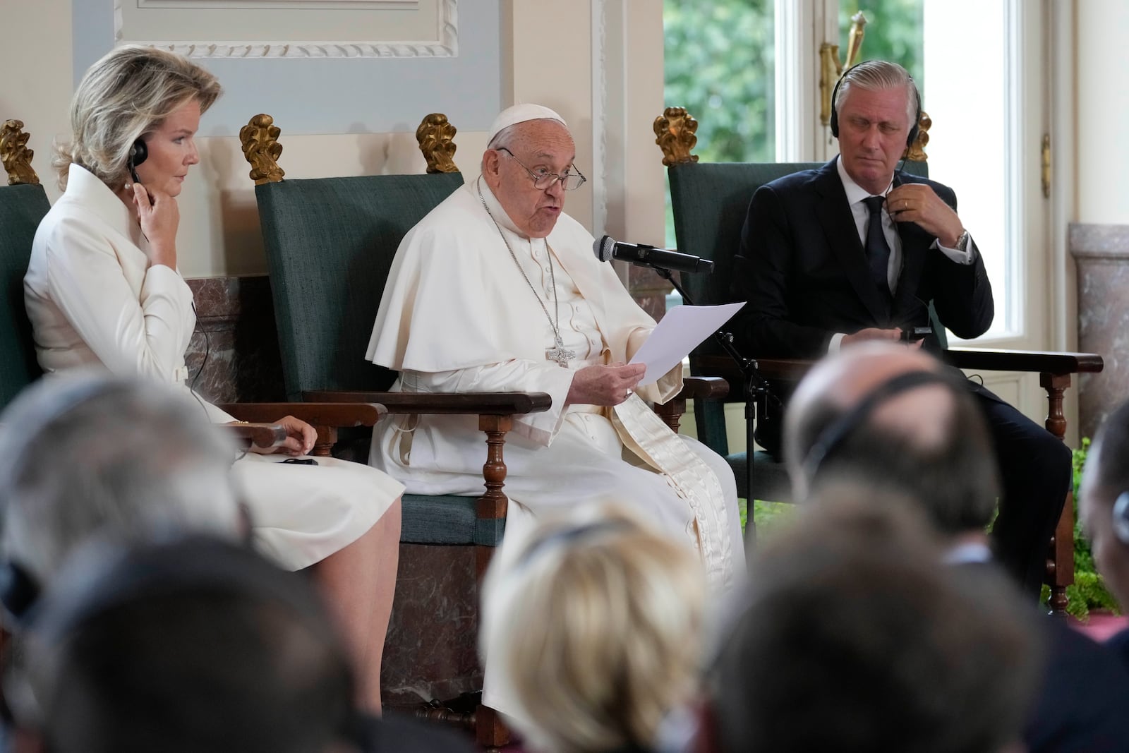 Pope Francis flanked by King Philippe and Queen Mathilde delivers his message during a meeting with the authorities and the civil society in the Grande Galerie of the Castle of Laeken, Brussels, Friday, Sept. 27, 2024. (AP Photo/Andrew Medichini)