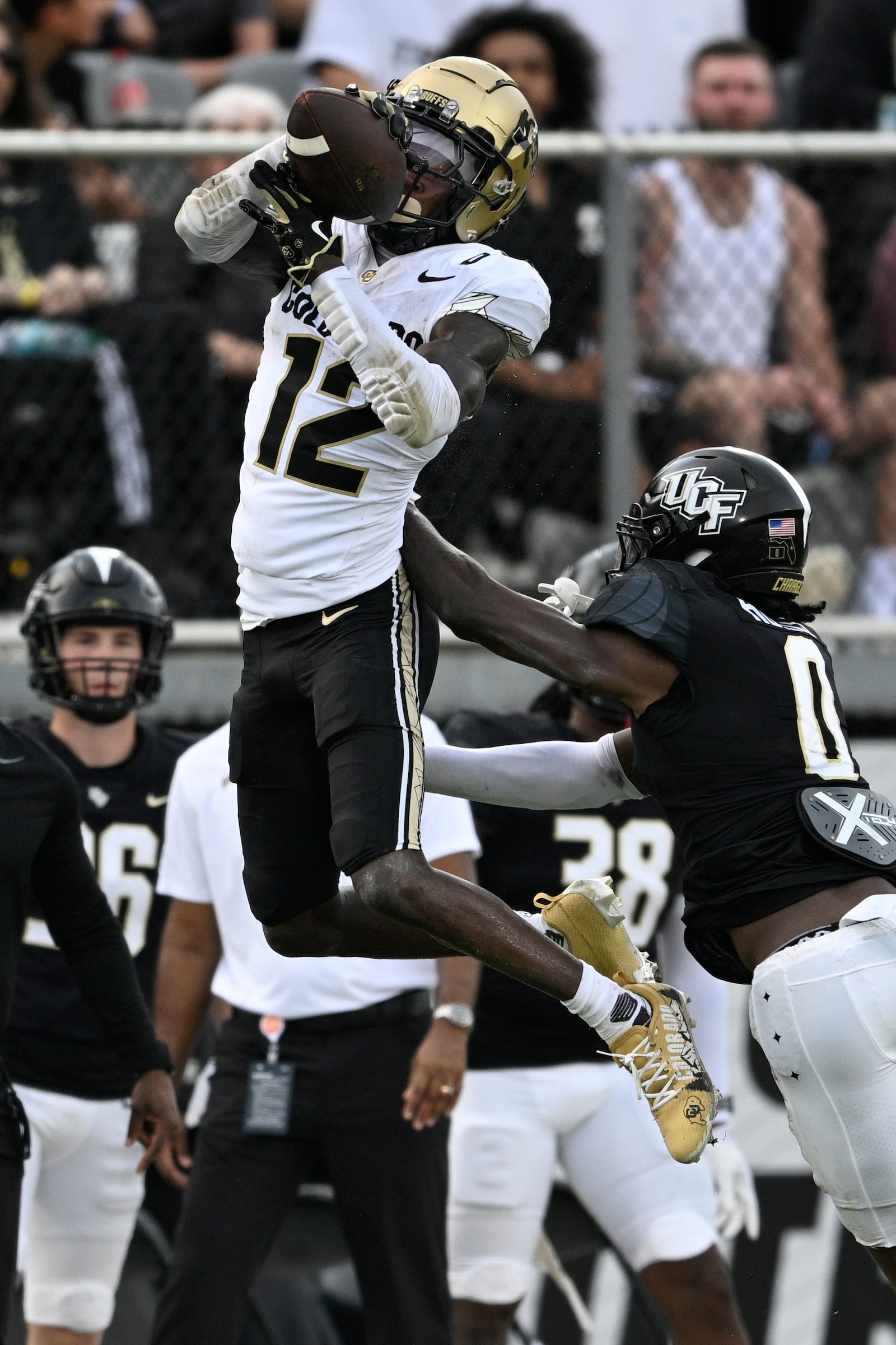 Colorado wide receiver Travis Hunter (12) catches a pass as Central Florida defensive back Brandon Adams (0) defends during the first half of an NCAA college football game, Saturday, Sept. 28, 2024, in Orlando, Fla. (AP Photo/Phelan M. Ebenhack)