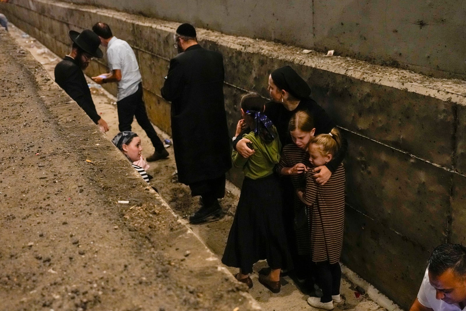 People take cover on the side of the road as a siren sounds a warning of incoming missiles on a freeway in Shoresh, Israel Tuesday, Oct. 1, 2024. (AP Photo/Ohad Zwigenberg)