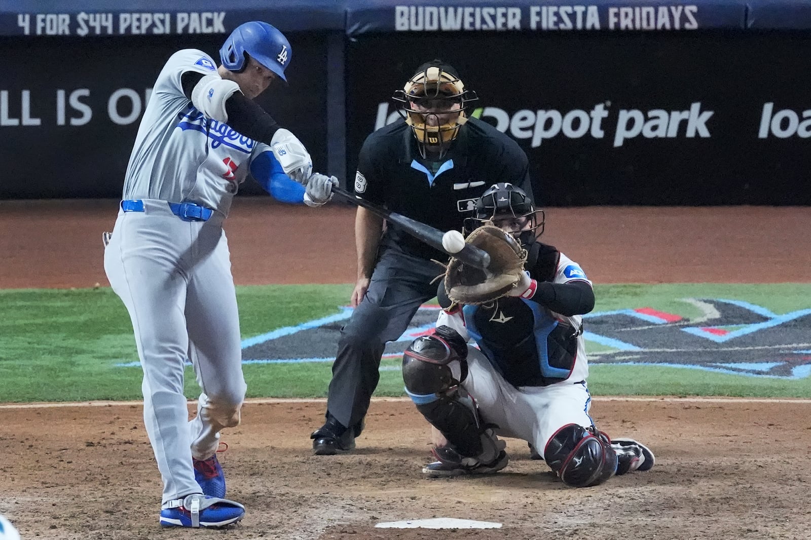 Los Angeles Dodgers' Shohei Ohtani, of Japan, hits a home run, scoring Max Muncy and Chris Taylor, during the ninth inning of a baseball game against the Miami Marlins, Thursday, Sept. 19, 2024, in Miami. (AP Photo/Wilfredo Lee)