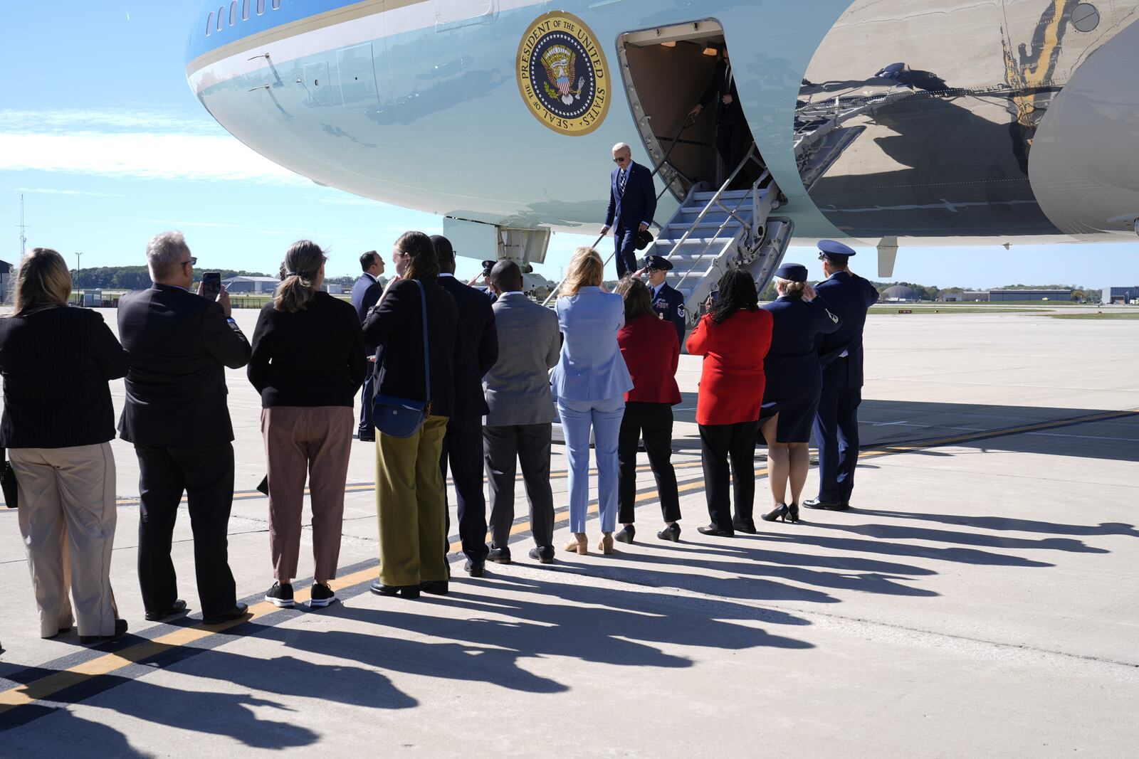 President Joe Biden is greeted by officials as he arrives at Milwaukee Mitchell International Airport in Milwaukee, Tuesday, Oct. 8, 2024. (AP Photo/Susan Walsh)