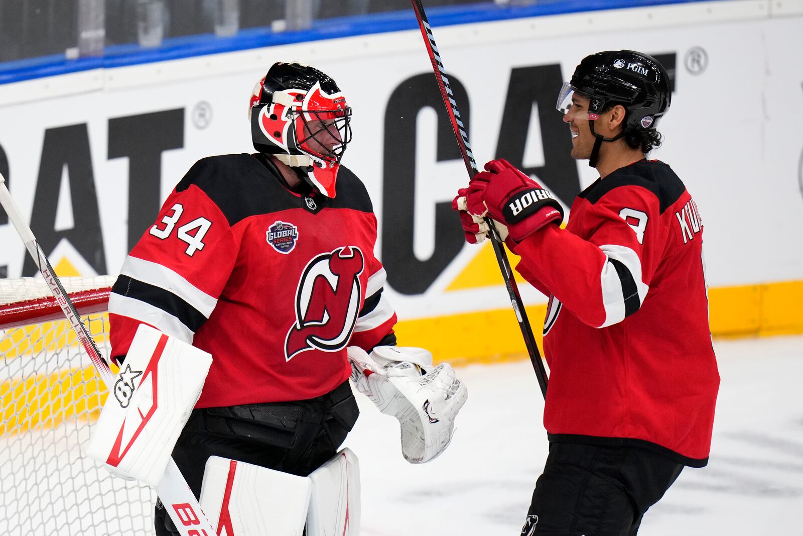 New Jersey Devils' Jake Allen, left, and New Jersey Devils' Johnathan Kovacevic ceelbrate after the NHL hockey game between Buffalo Sabres and New Jersey Devils, in Prague, Czech Republic, Saturday, Oct. 5, 2024. (AP Photo/Petr David Josek)