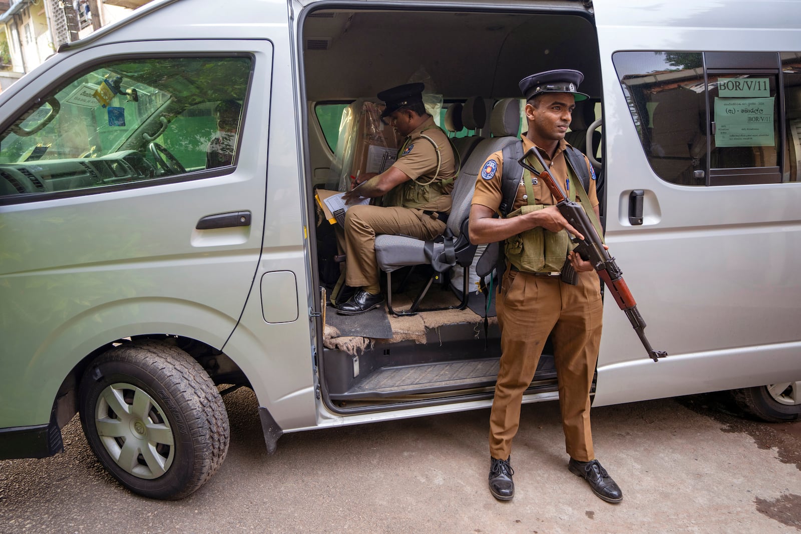 A police officer sits next to a sealed ballot box as polling officials prepare to return it to a counting center at the end of voting during presidential election in Colombo, Sri Lanka, Saturday, Sept. 21, 2024. (AP Photo/Rajesh Kumar Singh)