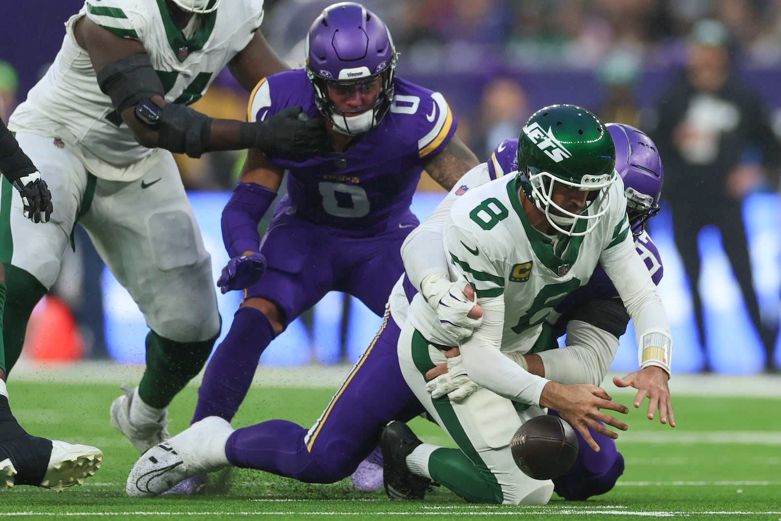 New York Jets quarterback Aaron Rodgers (8), right, is sacked by Minnesota Vikings' Harrison Phillips during the second half of an NFL football game, Sunday, Oct. 6, 2024, at the Tottenham Hotspur stadium in London. (AP Photo/Ian Walton)