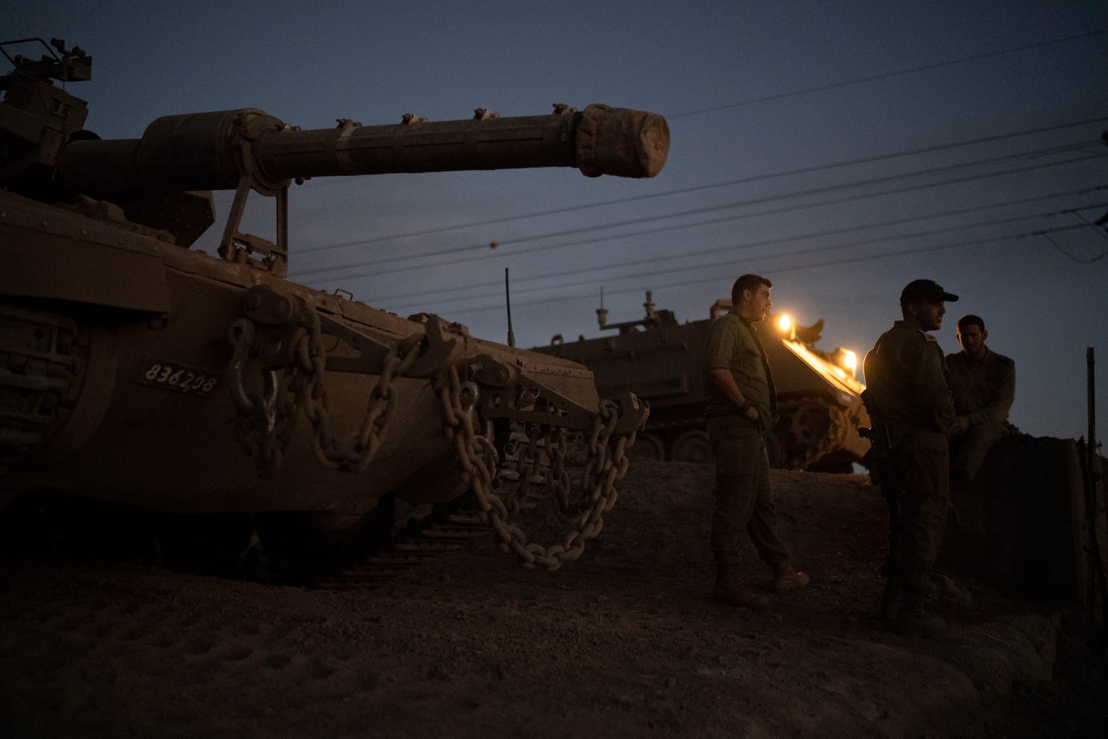 Israeli soldiers stand next to a tank on an area in the Israeli-annexed Golan Heights, Thursday, Sept. 19, 2024. (AP Photo/Leo Correa)