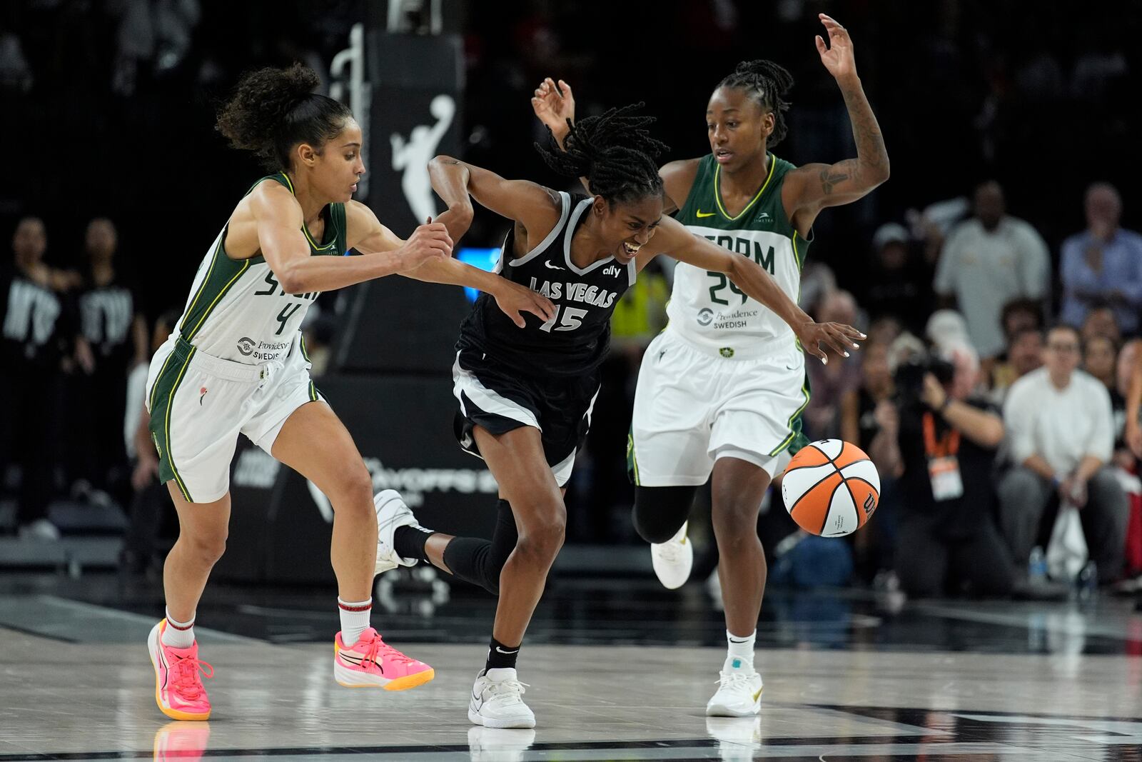 Las Vegas Aces guard Tiffany Hayes (15) drives against Seattle Storm guard Skylar Diggins-Smith (4) and guard Jewell Loyd (24) during the second half in Game 2 of a WNBA basketball first-round playoff game Tuesday, Sept. 24, 2024, in Las Vegas. (AP Photo/John Locher)