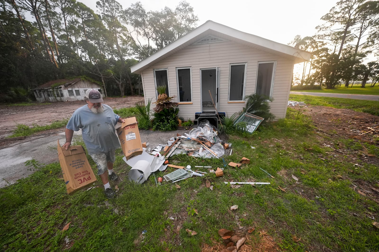 Will Marx cleans up remodeling debris in advance of Tropical Storm Helene, expected to become a hurricane before landfall, in Panacea, Fla., Wednesday, Sept. 25, 2024. (AP Photo/Gerald Herbert)