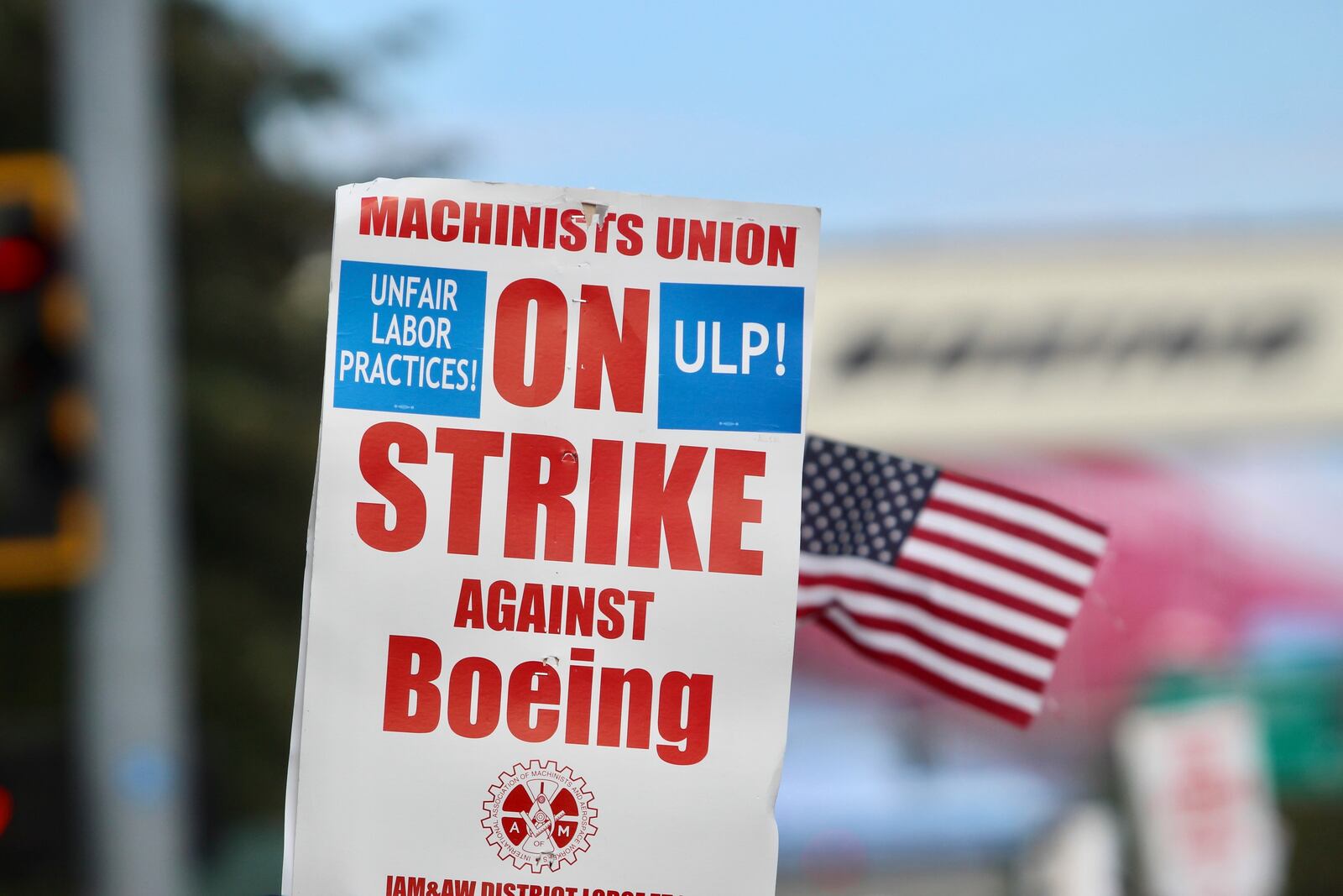 A strike sign is waved at union machinist picket line near Boeing's factory in Everett, Washington, Thursday, Sept. 19, 2024. (AP Photo/Manuel Valdes)