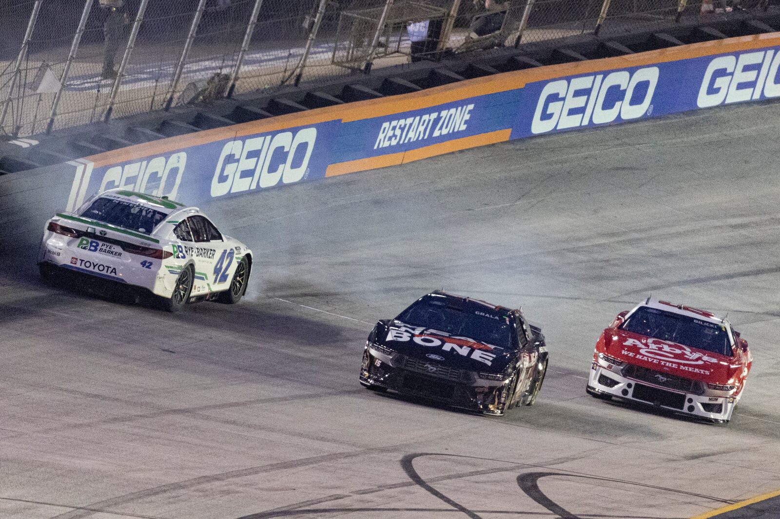 John Hunter Nemechek (42) spins while coming out of Turn 4 as Kaz Grala (15) and Josh Bilicki (66) avoid him during a NASCAR Cup Series auto race, Saturday, Sept. 21, 2024, in Bristol, Tenn. (AP Photo/Wade Payne)