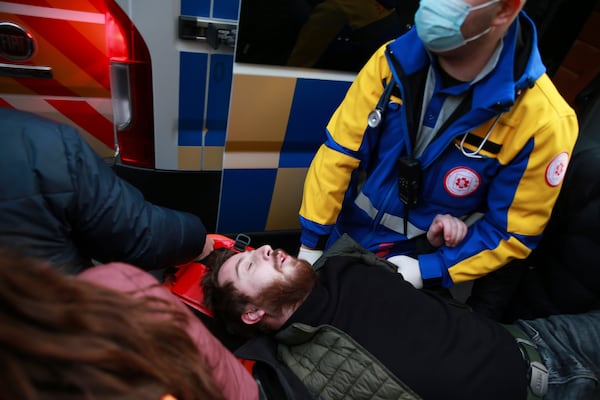 Demonstrators and paramedics carry a wounded after the clashes between police and protesters to an ambulance on a street during a rally against the results of the parliamentary elections amid allegations that the vote was rigged in Tbilisi, Georgia, on Tuesday, Nov. 19, 2024. (AP Photo/Zurab Tsertsvadze)