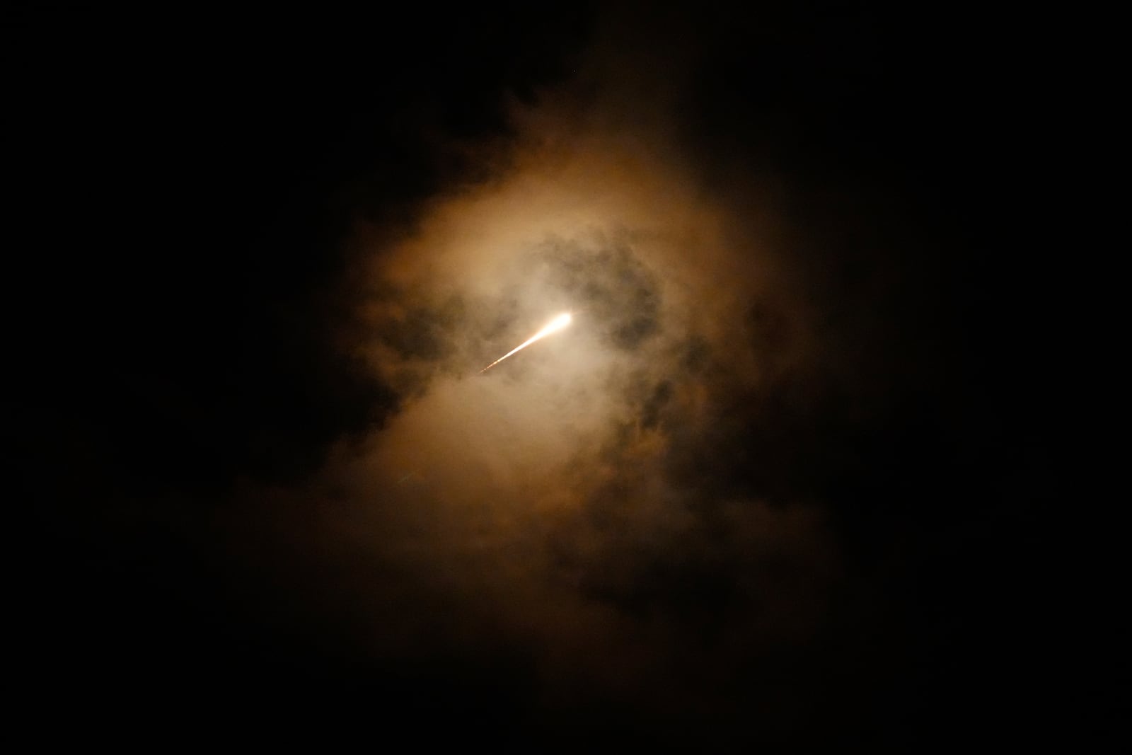 Projectiles fly through the sky in central Israel as a siren sounds a warning of incoming missiles fired from Iran towards Israel, Tuesday, Oct. 1, 2024. (AP Photo/Ohad Zwigenberg)