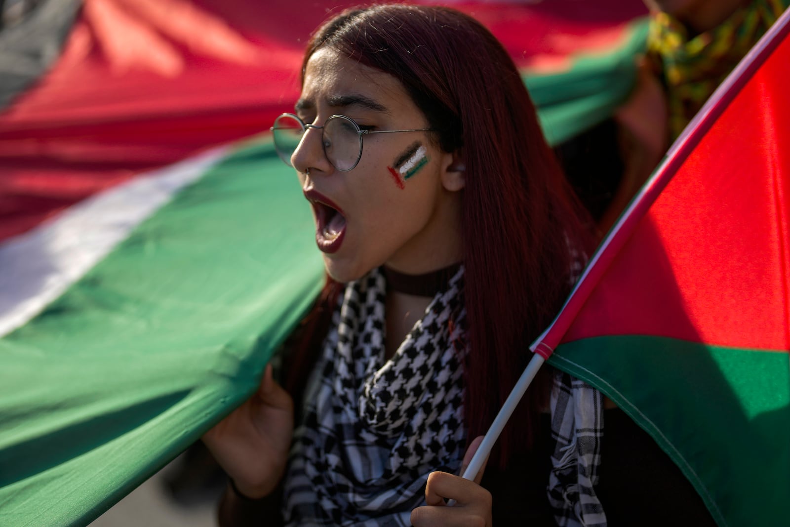 A demonstrator hold a Palestinian flag and chants slogans during a pro Palestinian protest in Istanbul, Turkey, Saturday, Oct. 5, 2024. (AP Photo/Khalil Hamra)