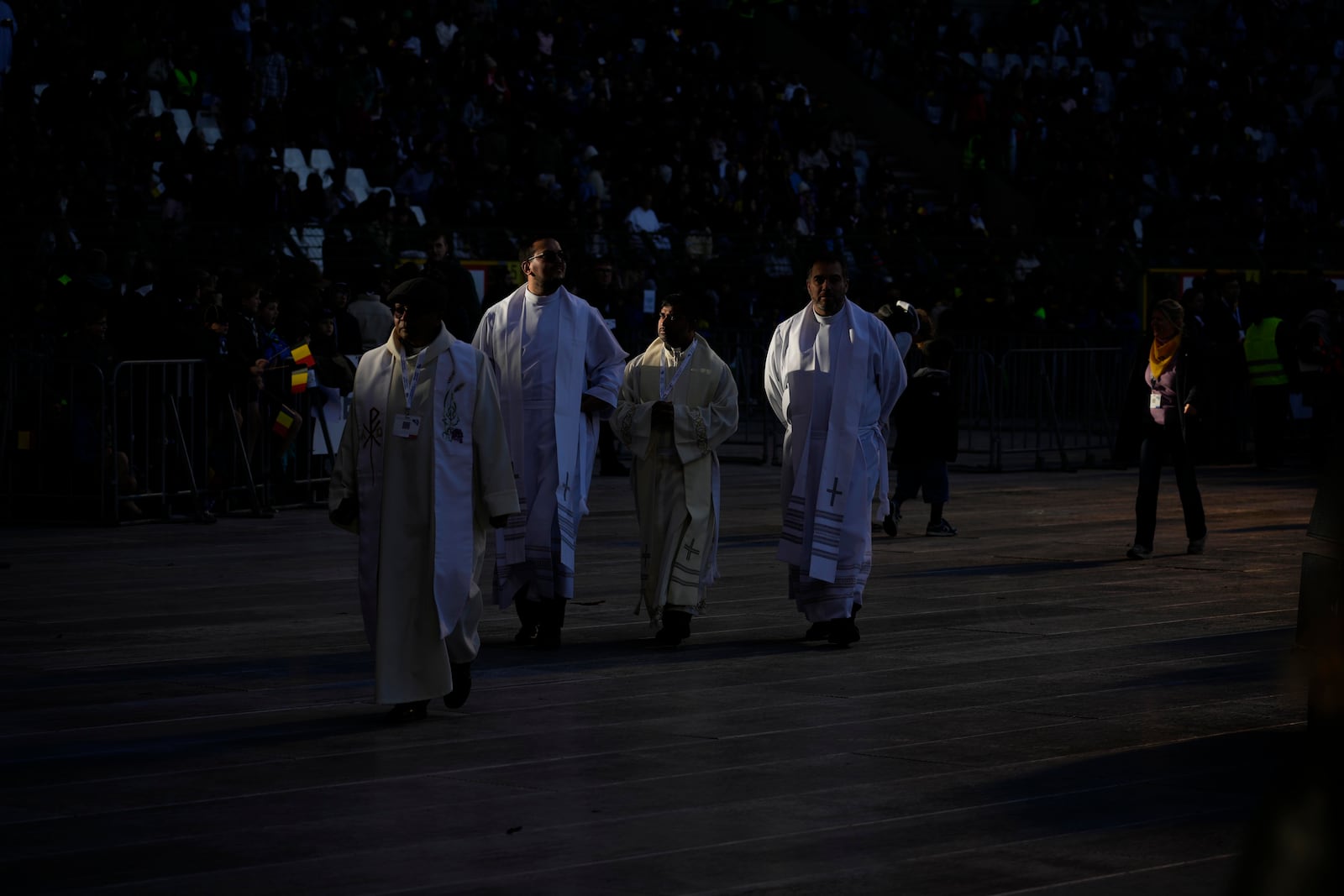 Priests wait for the start of a mass presided by Pope Francis at King Baudouin Stadium, in Brussels Sunday, Sept. 29, 2024. (AP Photo/Andrew Medichini)