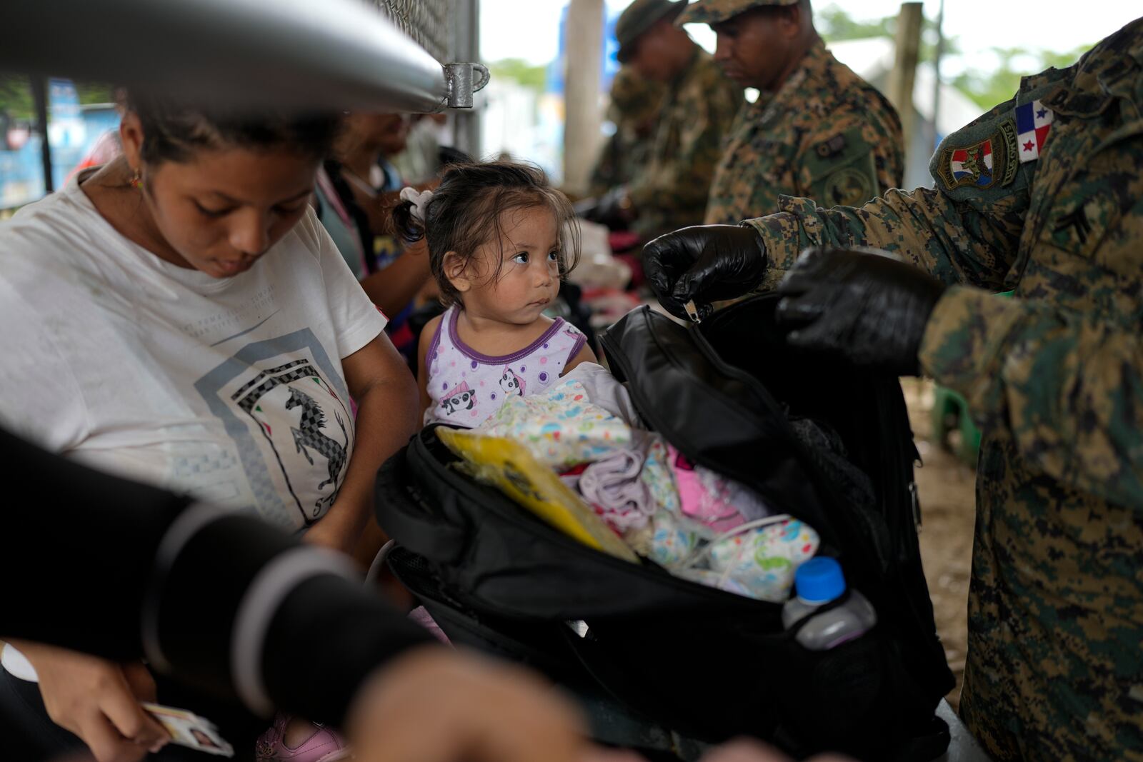 Panamanian police inspect the luggage of Francismar Acosta, from Venezuela, in Lajas Blancas, Panama, after she trekked across the Darien Gap from Colombia with her daughter Adhara Figueroa, Thursday, Sept. 26, 2024. (AP Photo/Matias Delacroix)