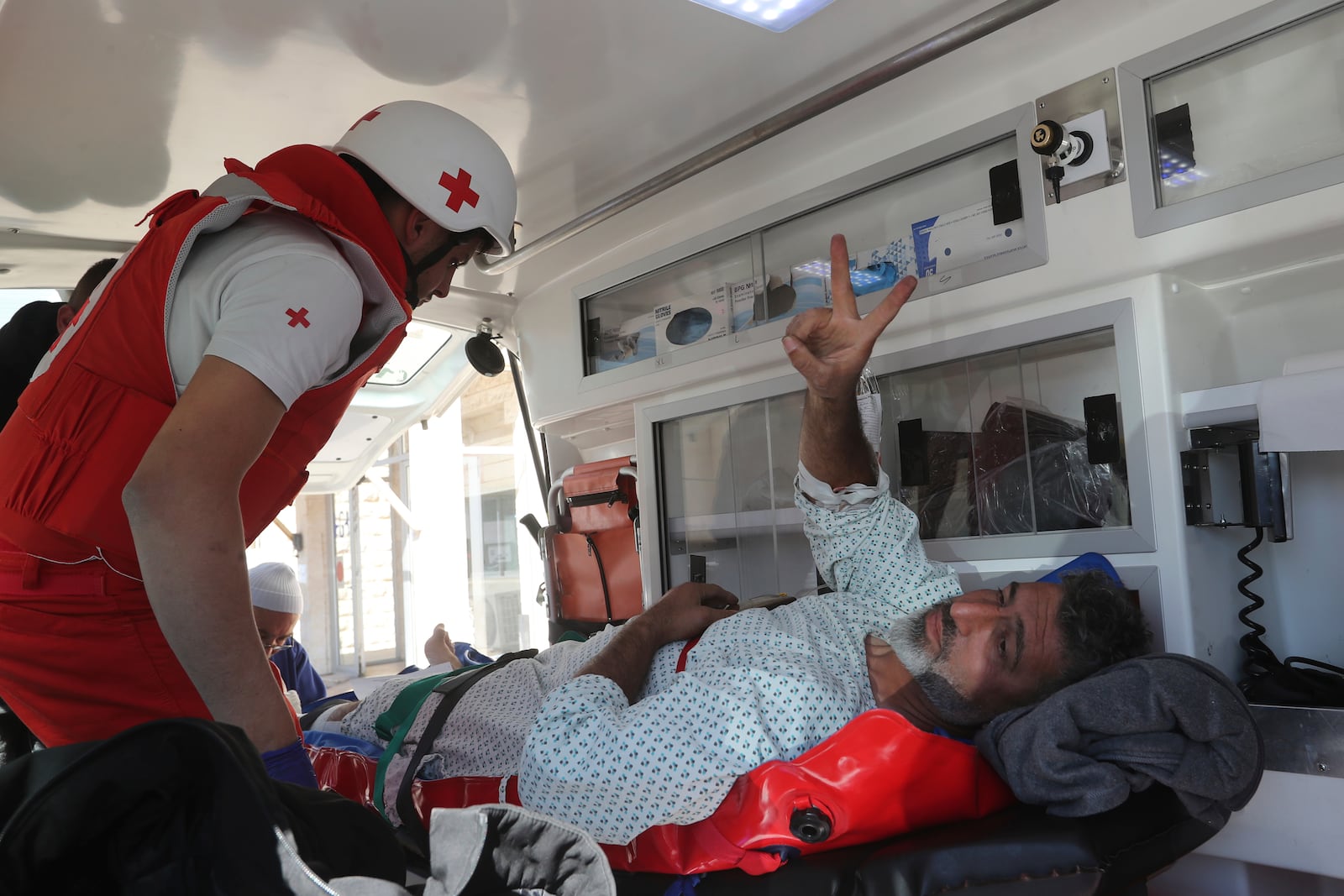 An injured cameraman flashes victory sign as he moved by the Lebanese Red Cross to a hospital after he injured at the site where an Israeli airstrike hit a compound housing journalists, killing three media staffers from two different news agencies according to Lebanon's state-run National News Agency, in Hasbaya village, southeast Lebanon, Friday, Oct. 25, 2024. (AP Photo/Mohammed Zaatari)