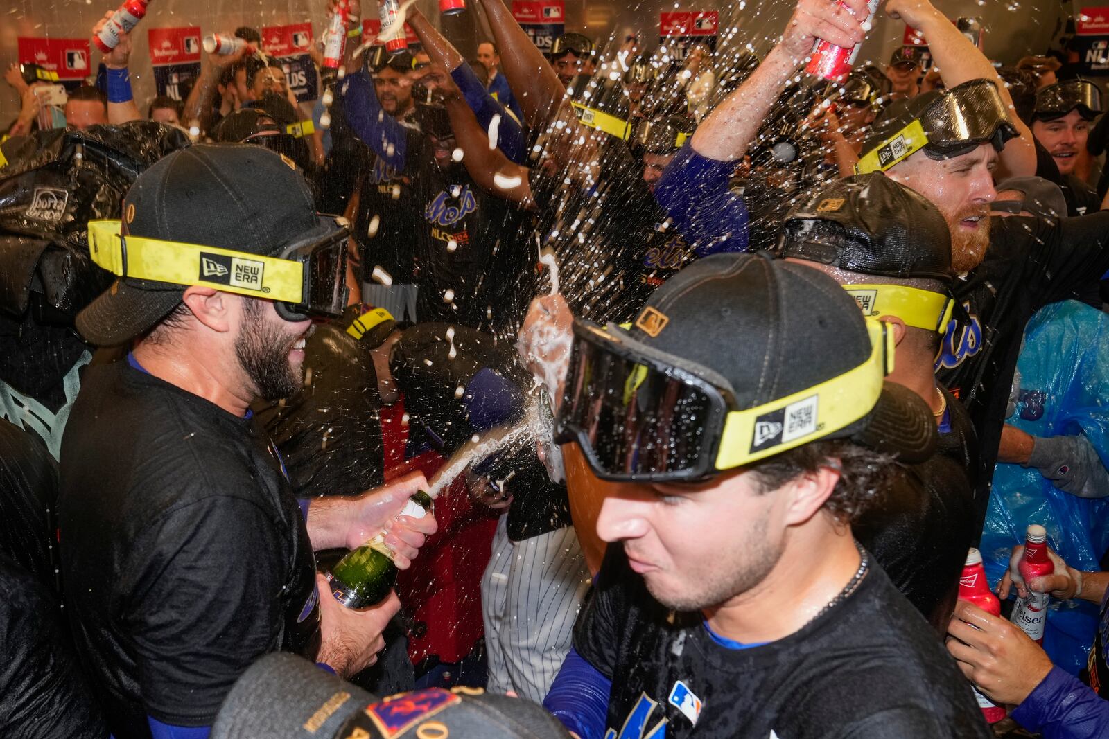 The New York Mets celebrate in the locker room after defeating the Philadelphia Phillies in Game 4 of the National League baseball playoff series, Wednesday, Oct. 9, 2024, in New York. (AP Photo/Frank Franklin II)