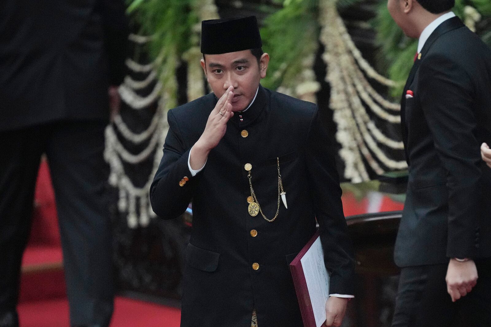 Indonesia's newly-inaugurated Vice President Gibran Rakabuming Raka, who is also the eldest son of outgoing President Joko Widodo, salutes during the presidential inauguration ceremony at the Parliament building in Jakarta, Indonesia, Sunday, Oct. 20, 2024. (AP Photo/Tatan Syuflana)