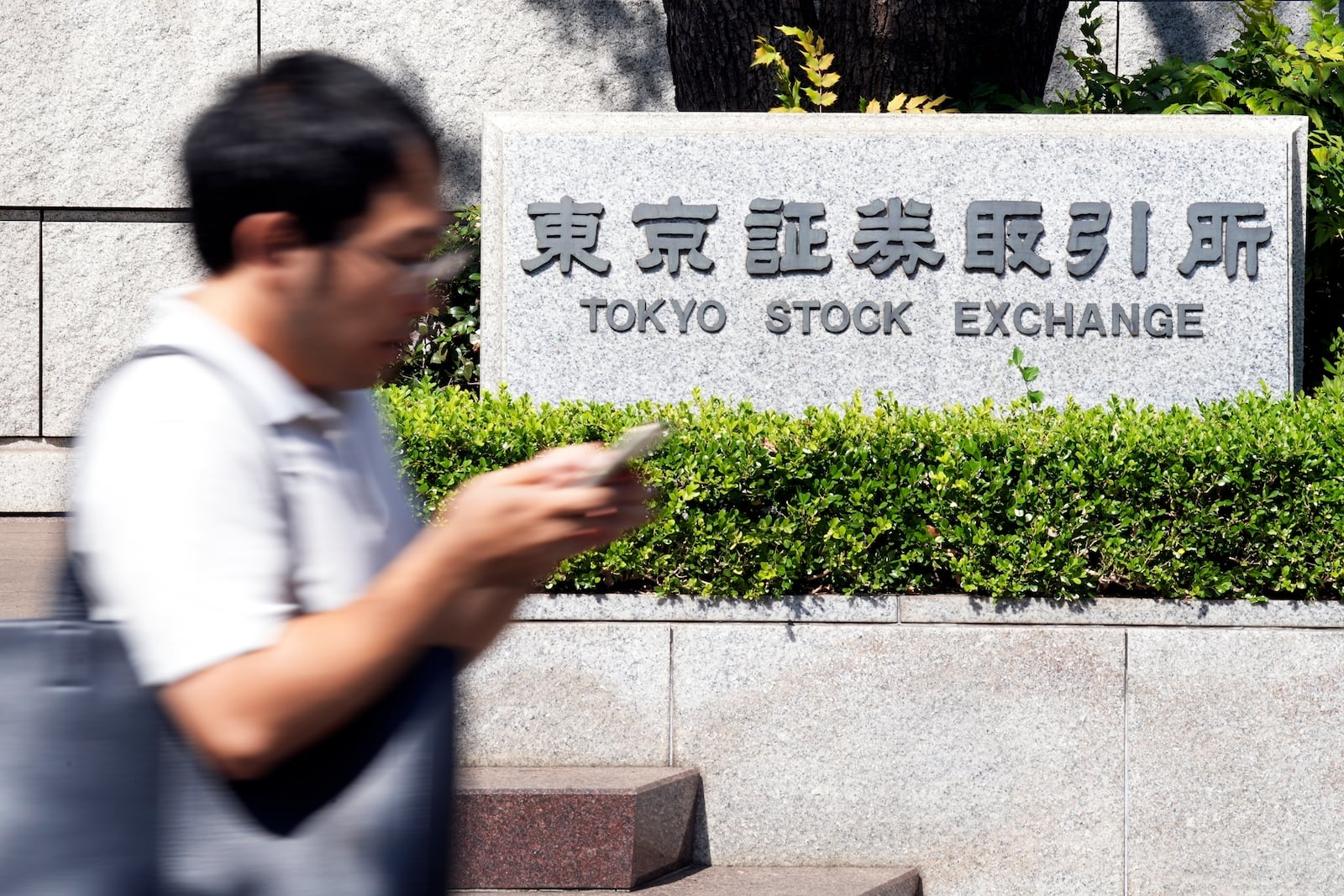 FILE - A person walks in front of the Tokyo Stock Exchange building Wednesday, Oct. 2, 2024, in Tokyo. (AP Photo/Eugene Hoshiko, File)