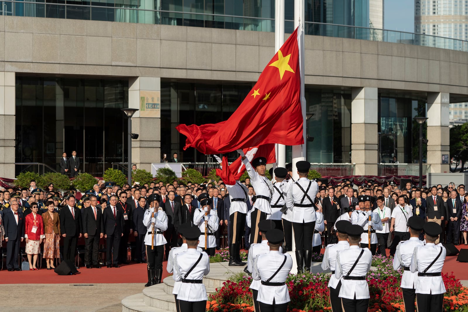 A Hong Kong police guard of honor rises China and Hong Kong flags during a flag raising ceremony for the celebration of the 75th National Day of the People's Republic of China in Hong Kong, Tuesday, Oct. 1, 2024. (AP Photo/Chan Long Hei)