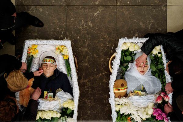 FILE- Mothers cries over the coffins of their children Danylo Nikittskyi, 15, and Alina Kutsenko, 15, killed by a Russian missile, during a funeral ceremony in Kryvyi Rih, Ukraine, April 7, 2025. (AP Photo/Evgeniy Maloletka, File)