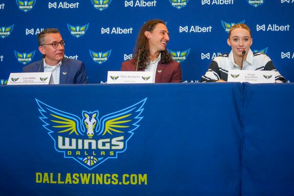 Dallas Wings' Paige Bueckers, right, selected No. 1 overall in the WNBA basketball draft, sits next to Wings' vice president and general manager Curt Miller, left, and head coach Chris Koclanes during an introductory press conference Wednesday, April 23, 2025, in Dallas. (AP Photo/Julio Cortez)