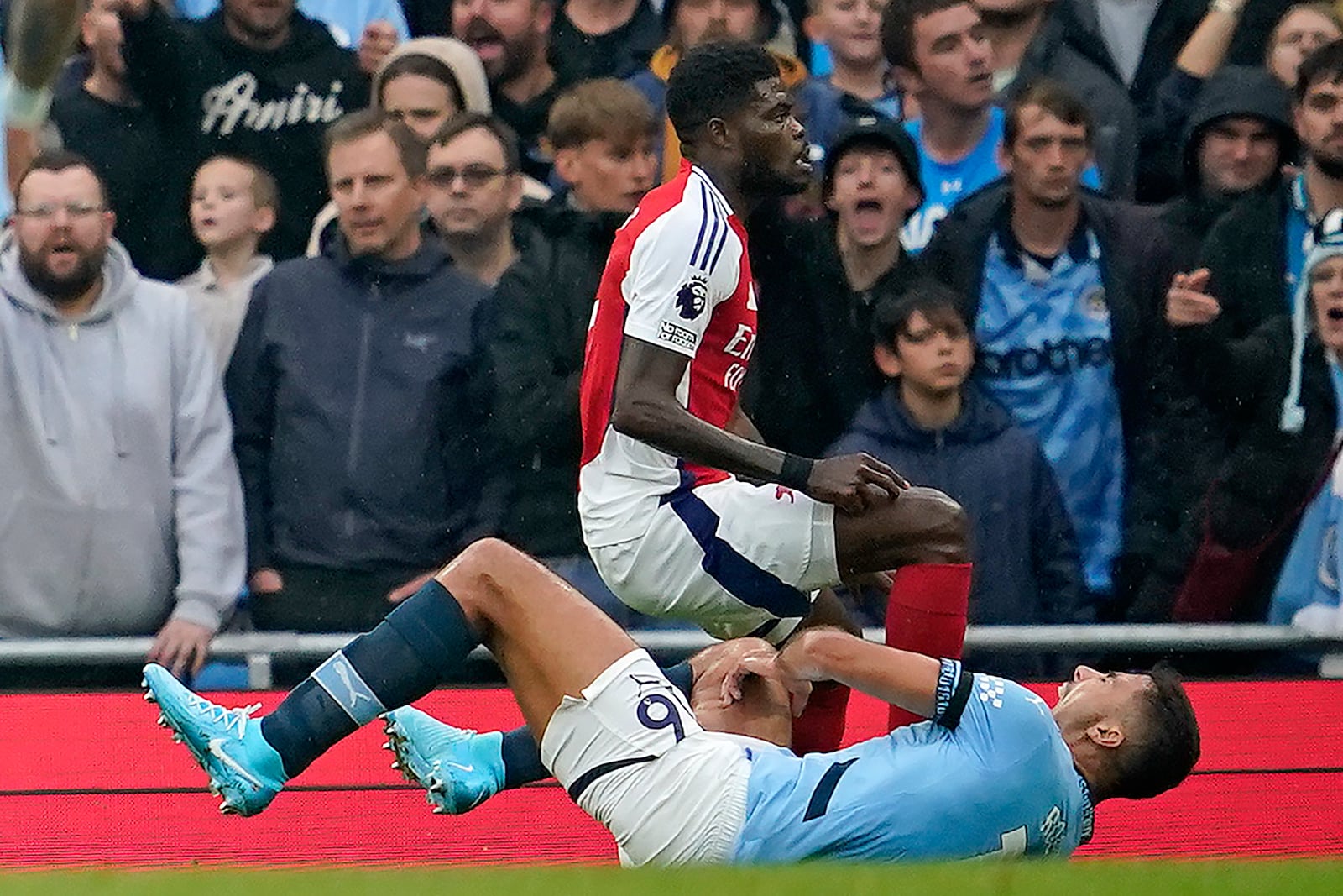 Manchester City's Rodri is injured next to Arsenal's Thomas Partey during the English Premier League soccer match between Manchester City and Arsenal at the Etihad stadium in Manchester, England, Sunday, Sept. 22, 2024. (AP Photo/Dave Thompson)