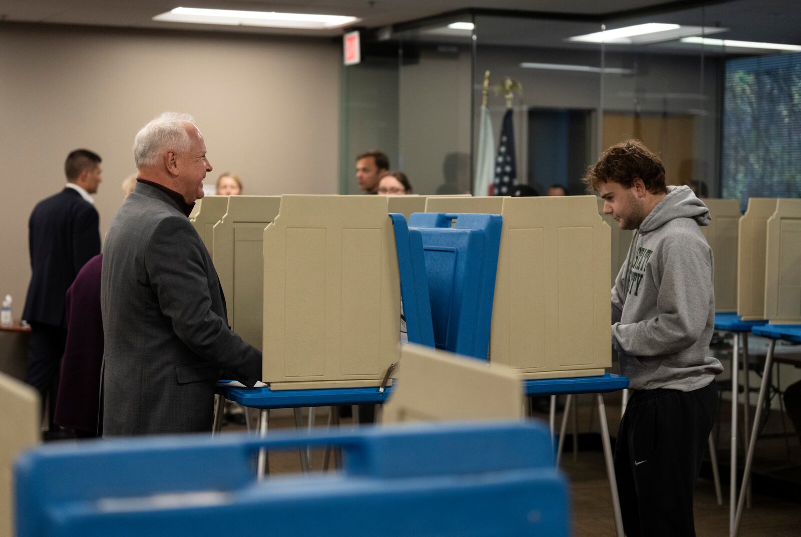 Minnesota Governor and Vice Presidential candidate Tim Walz, left, chats with his son, Gus Walz, a first time voter, as they cast their ballots during early voting at Ramsey County Elections in St. Paul, Minn., on Wednesday, October 23, 2024. (Renée Jones Schneider/Star Tribune via AP)