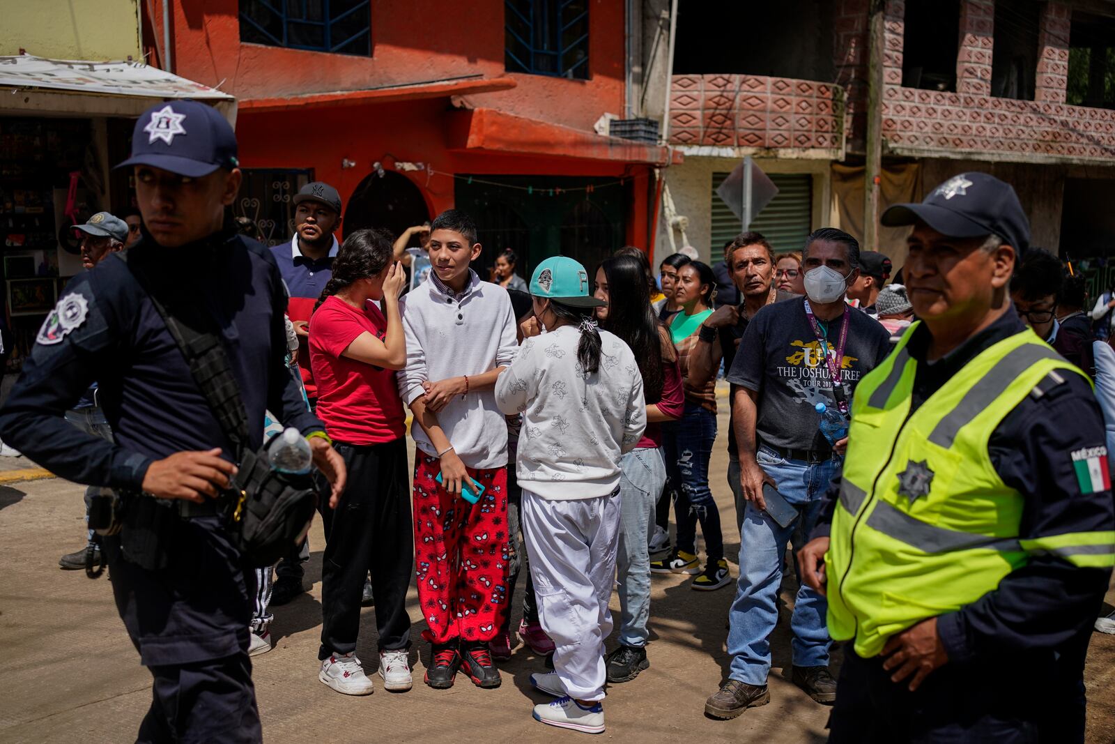 Residents gather near the site where various were buried after a landslide caused by rains, in Naucalpan, Mexico, Tuesday, Sept. 17, 2024. (AP Photo/Felix Marquez)