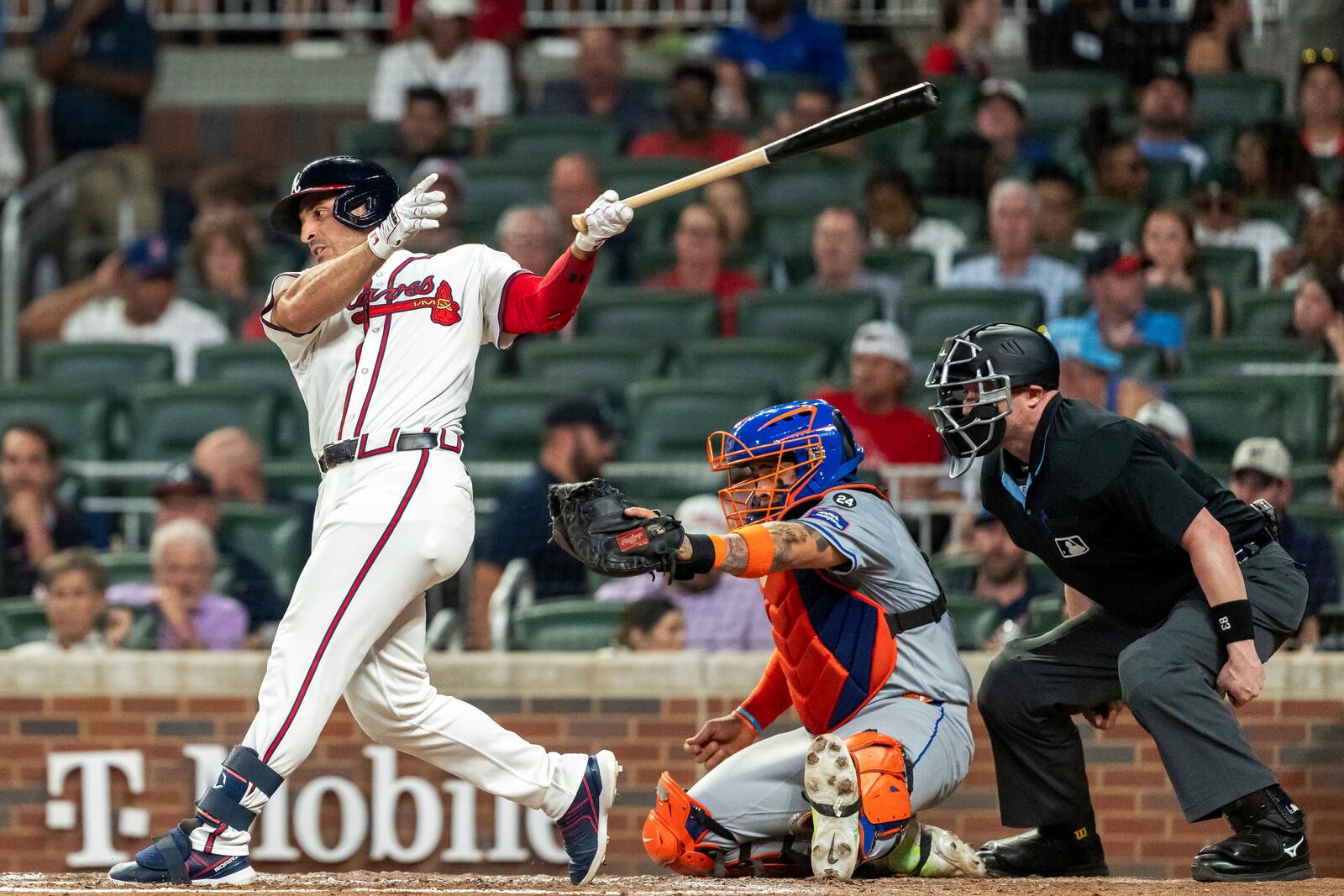 New York Mets catcher Francisco Alvarez, center, catches the ball as Atlanta Braves' Ramón Laureano, left, swings at a pitch in the third inning of a baseball game, Tuesday, Sept. 24, 2024, in Atlanta. (AP Photo/Jason Allen)