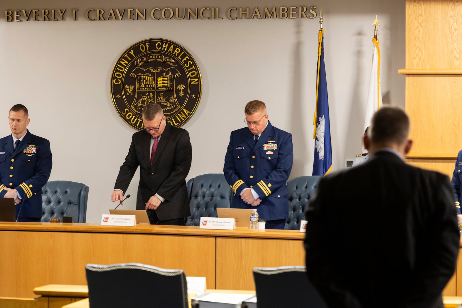 Coast Guard members of the investigative board for the Titan marine board formal hearing pause for a moment of silence inside the Charleston County Council Chambers Monday, Sept. 16, 2024, in North Charleston, S.C. (AP Photo/Mic Smith)