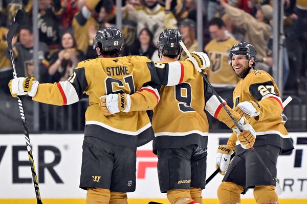 Vegas Golden Knights right wing Mark Stone (61), center Jack Eichel (9) and defenseman Shea Theodore (27) celebrate Stone's goal against the Minnesota Wild during the first period of Game 5 of a first-round NHL hockey playoff series Tuesday, April 29, 2025, in Las Vegas. (AP Photo/David Becker)