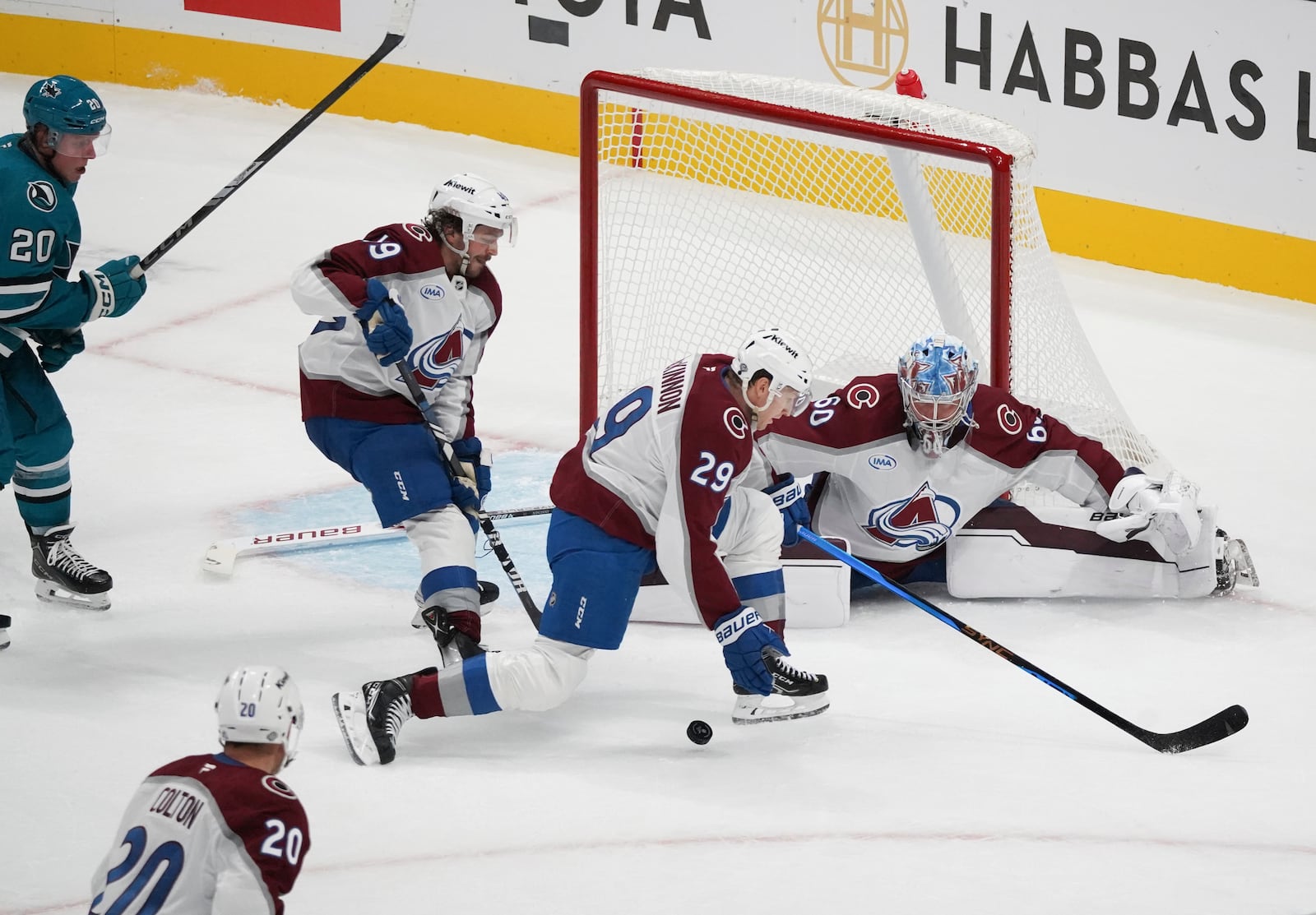 Colorado Avalanche players Samuel Girard (49), center left, Nathan MacKinnon (29), center right, and Justus Annunen (60), far right, defend a shot as San Jose Sharks left wing Fabian Zetterlund (20) looks to score during the third period of an NHL hockey game in San Jose, Calif., Sunday, Oct. 20, 2024. (AP Photo/Minh Connors)