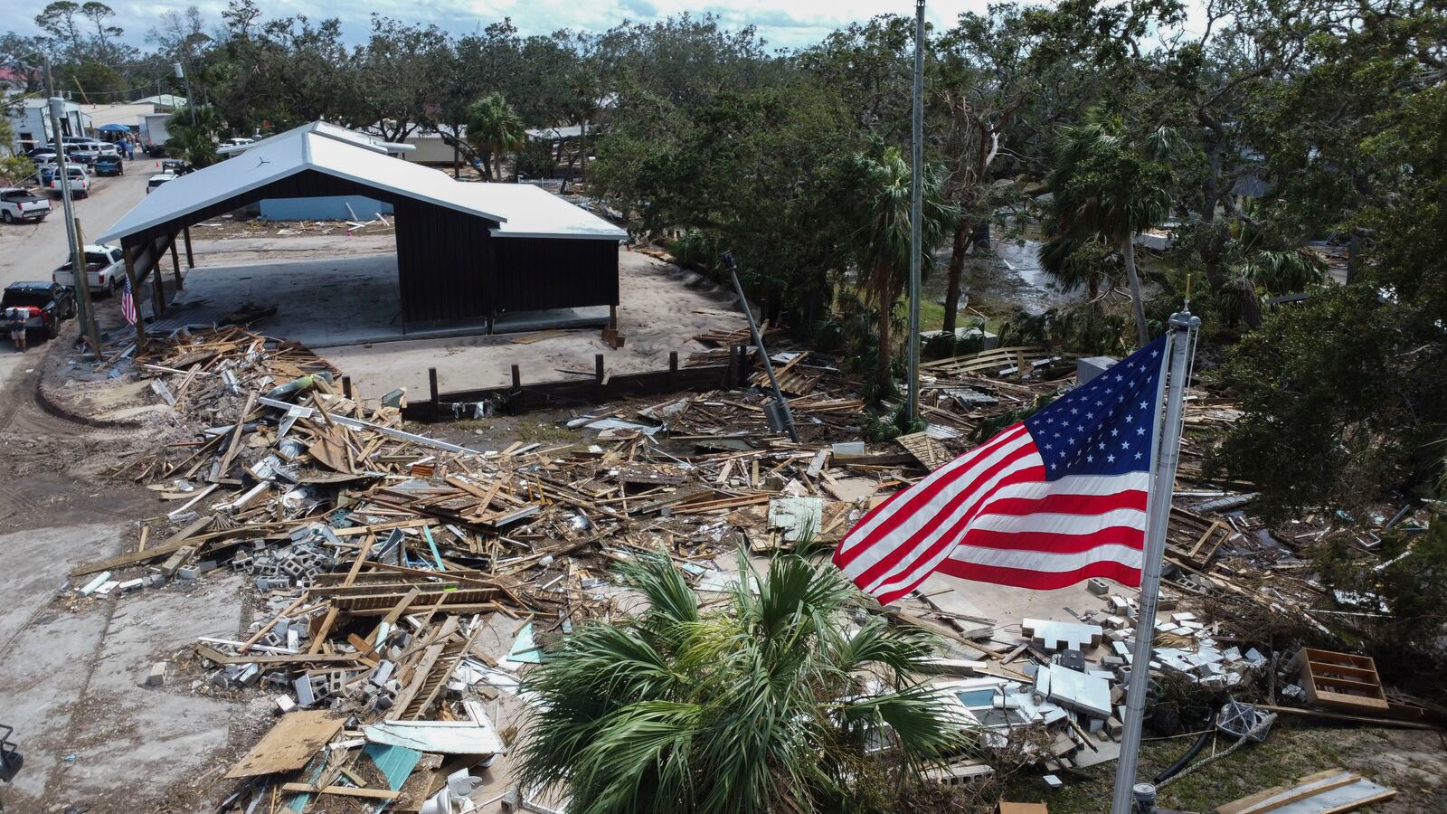 An American flag flies over the destroyed city hall in the aftermath of Hurricane Helene, in Horseshoe Beach, Fla., Saturday, Sept. 28, 2024. (AP Photo/Stephen Smith)