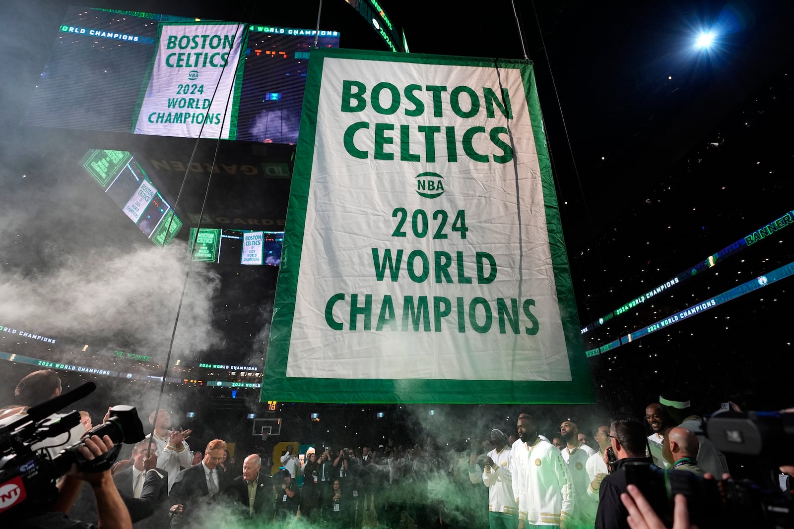 The Boston Celtics 2024 World Championship banner is raised prior to an NBA basketball game against the New York Knicks, Tuesday, Oct. 22, 2024, in Boston. (AP Photo/Charles Krupa)