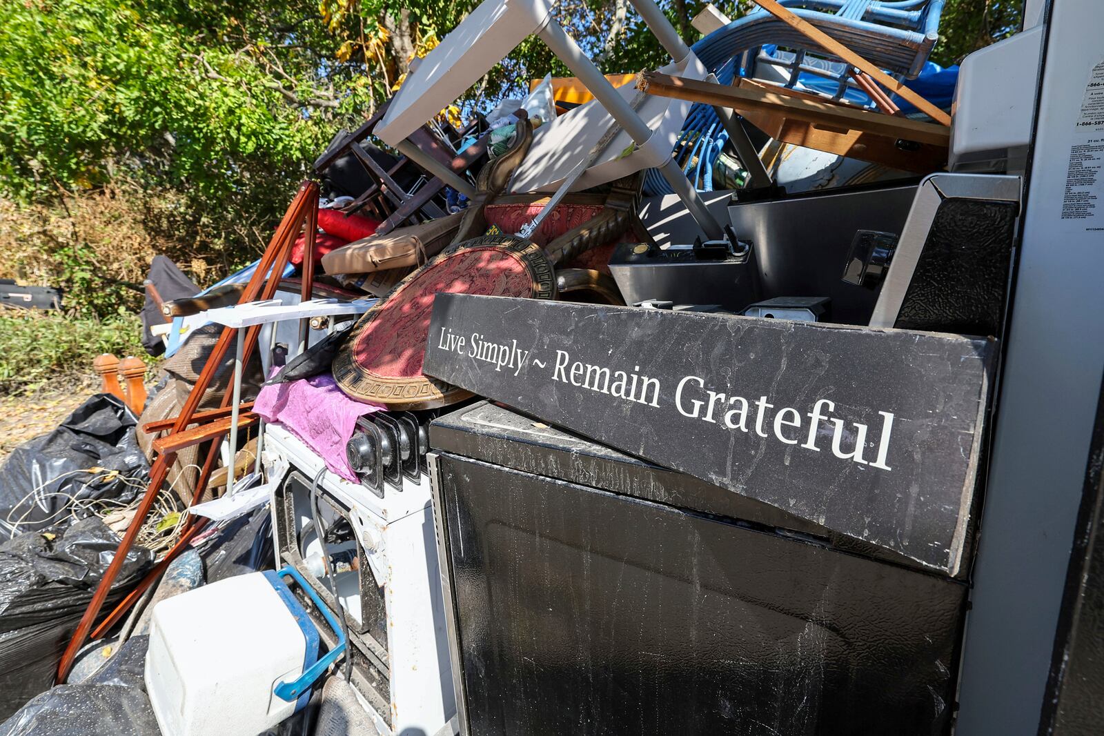 Contents of a home are plied on the side of a home after flooding from Hurricane Helene on Wednesday, Oct. 2, 2024, in Indian Rocks Beach, Fla. (AP Photo/Mike Carlson)