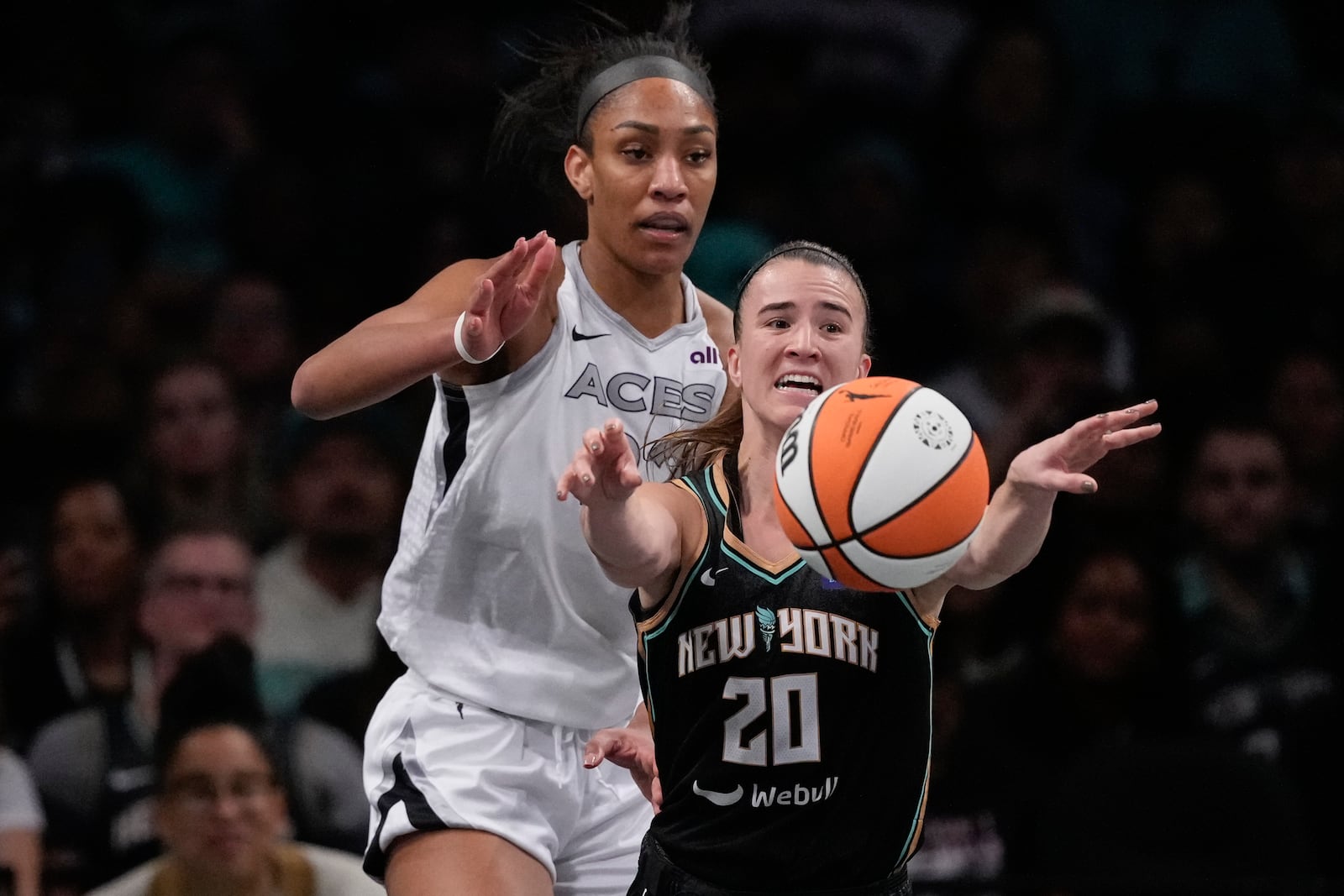 New York Liberty's Sabrina Ionescu (20) passes away from Las Vegas Aces' A'ja Wilson (22) during the second half of a WNBA basketball semifinal game, Tuesday, Oct. 1, 2024, in New York. The Liberty won 88-84. (AP Photo/Frank Franklin II)