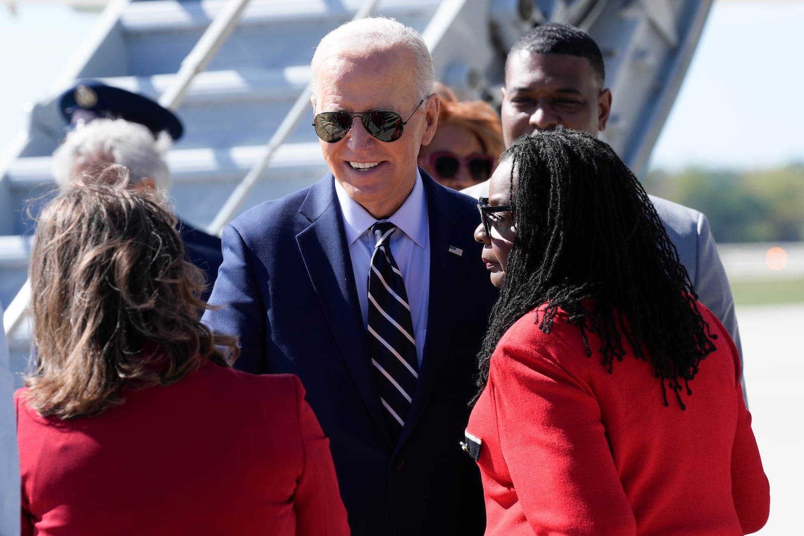 President Joe Biden is greeted by Rep. Gwen Moore, D-Wis., right, and other officials after arriving at Milwaukee Mitchell International Airport in Milwaukee, Tuesday, Oct. 8, 2024. (AP Photo/Susan Walsh)