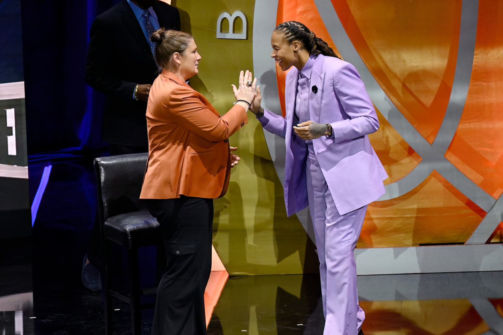 Seimone Augustus, right, slaps hands with Lindsay Whalen, left, during her enshrinement in the Basketball Hall of Fame, Sunday Oct. 13, 2024, in Springfield, Mass. (AP Photo/Jessica Hill)