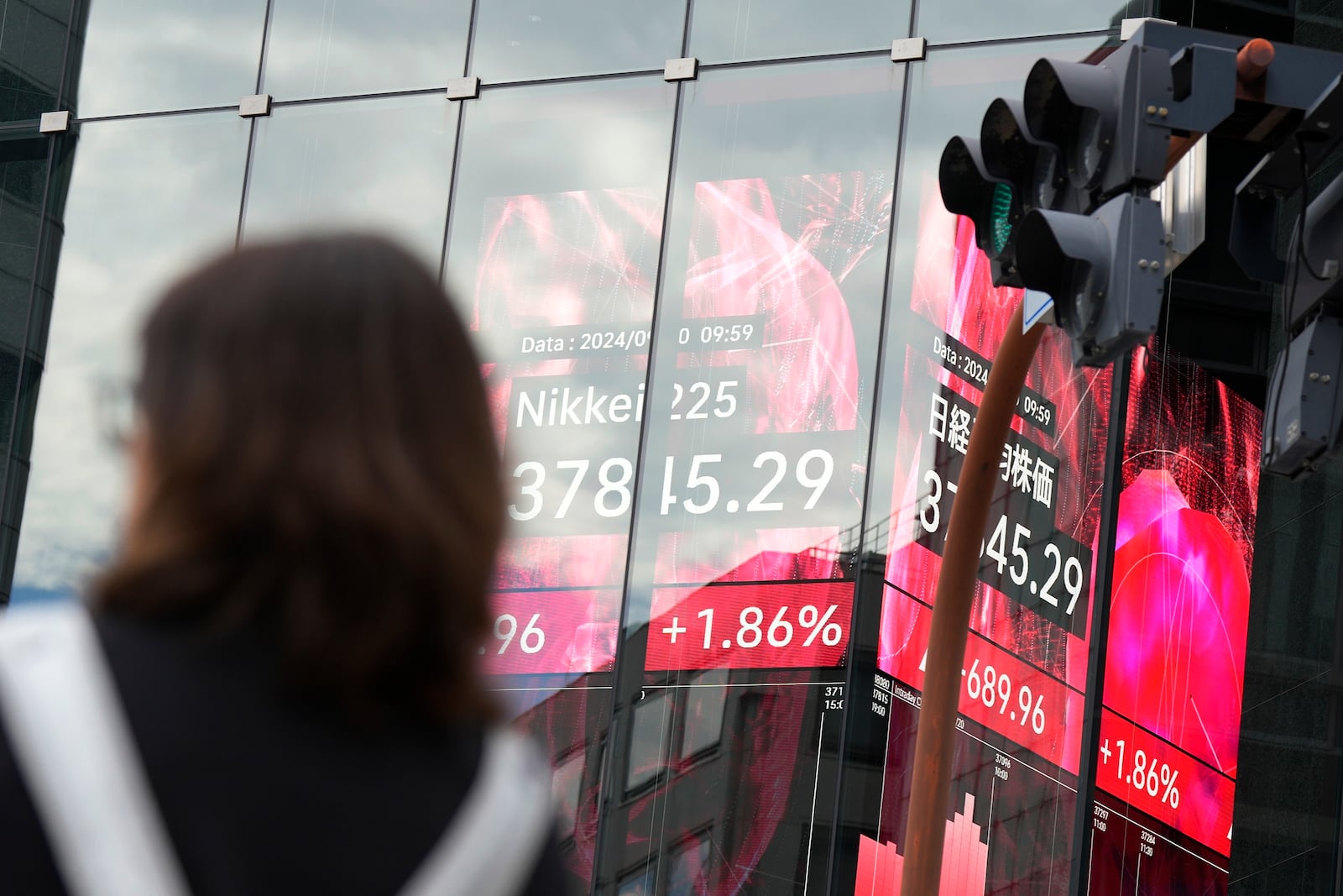 A person stands in front of an electronic stock board showing Japan's Nikkei index at a securities firm Friday, Sept. 20, 2024, in Tokyo. (AP Photo/Eugene Hoshiko)